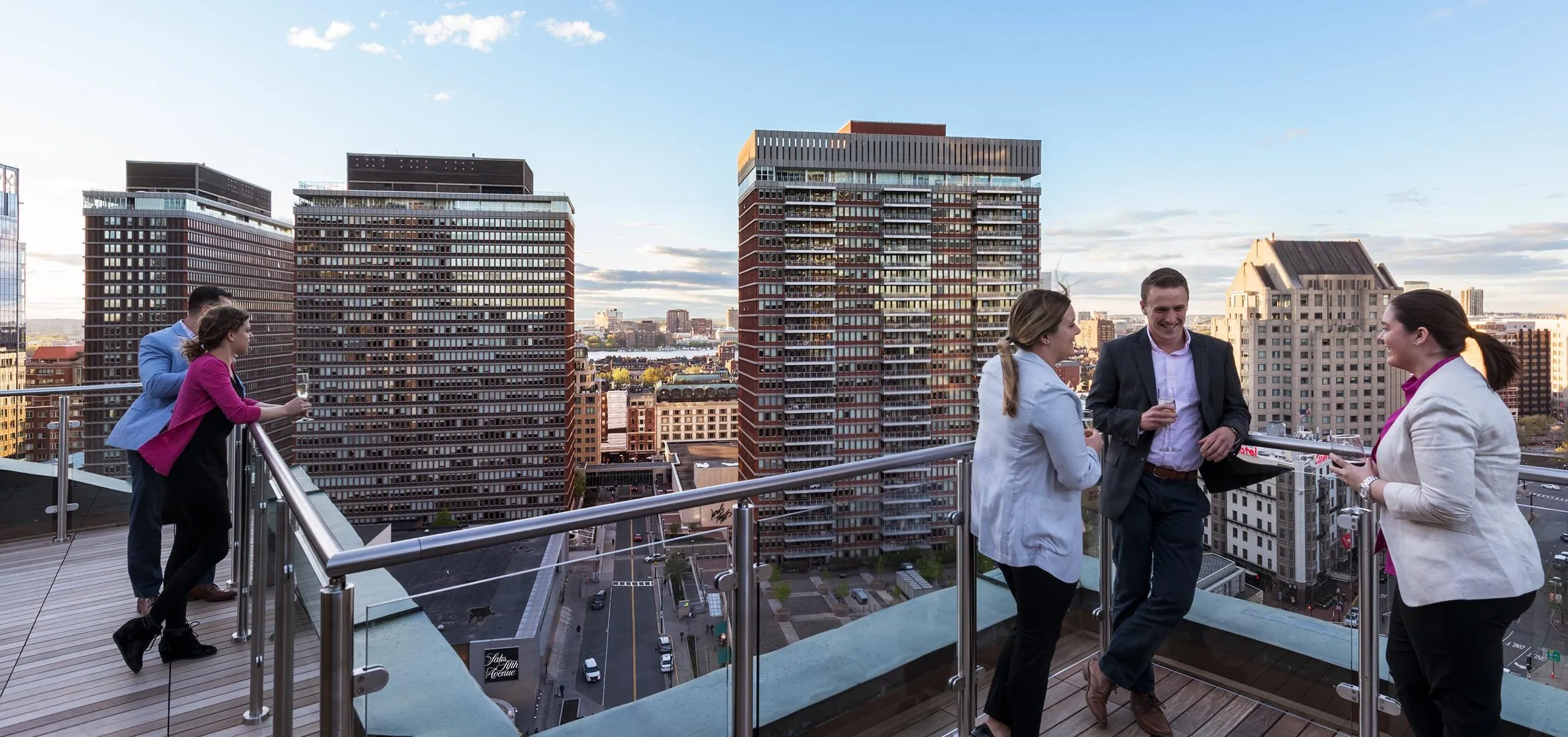 People standing on balcony of office building with skyline in the background