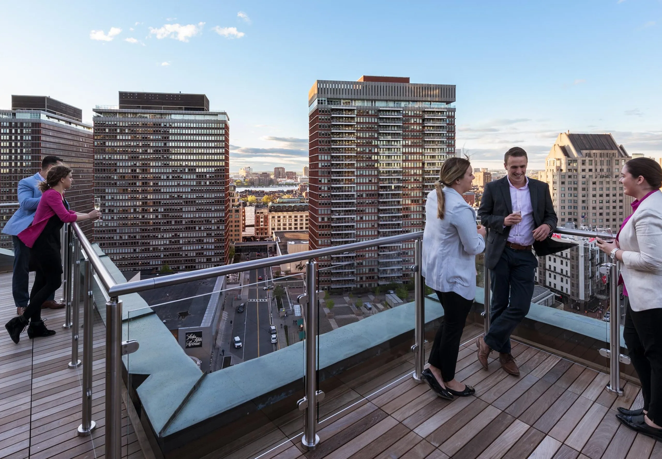 People standing on balcony of office building with skyline in the background