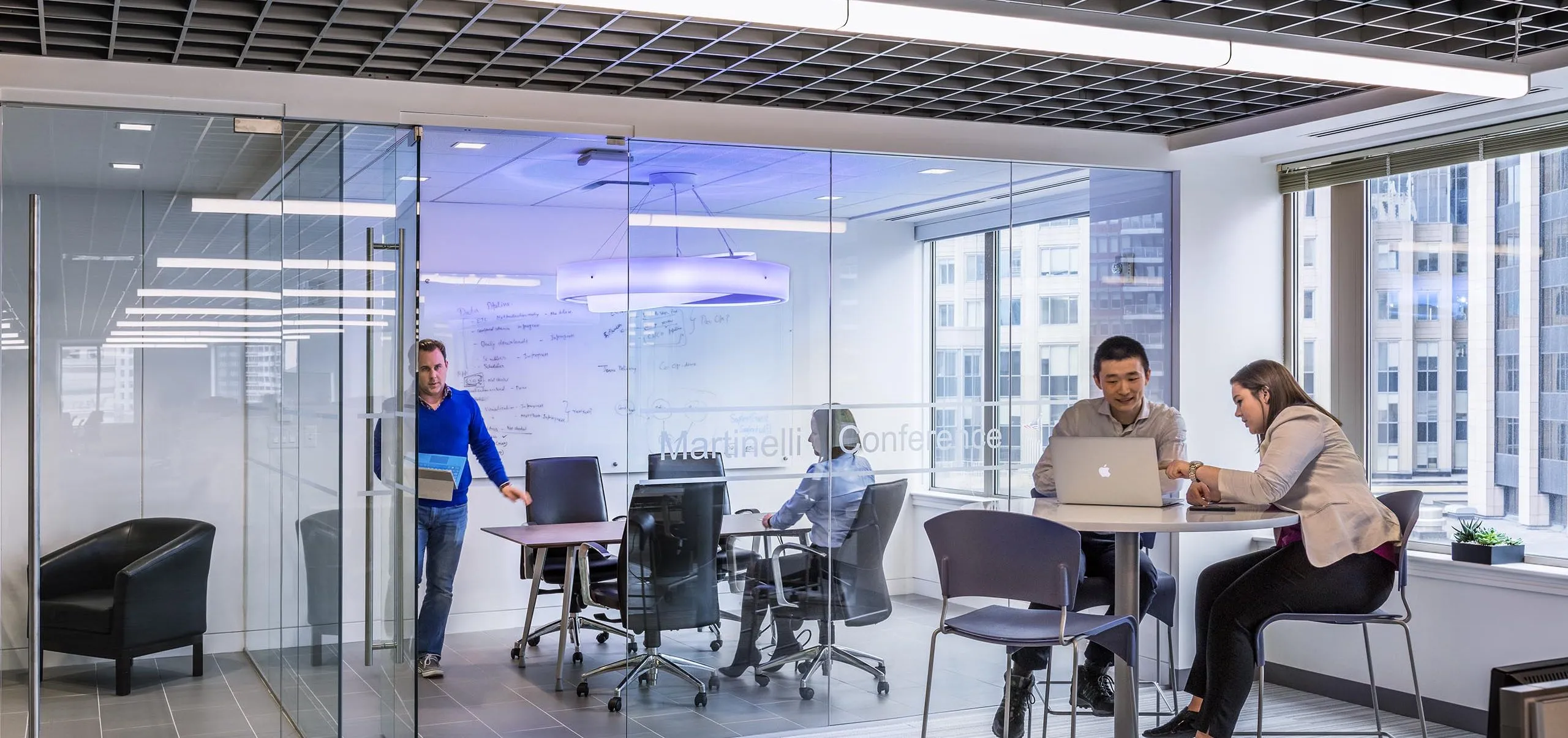 Communal seating and meeting rooms with glass walls in office building