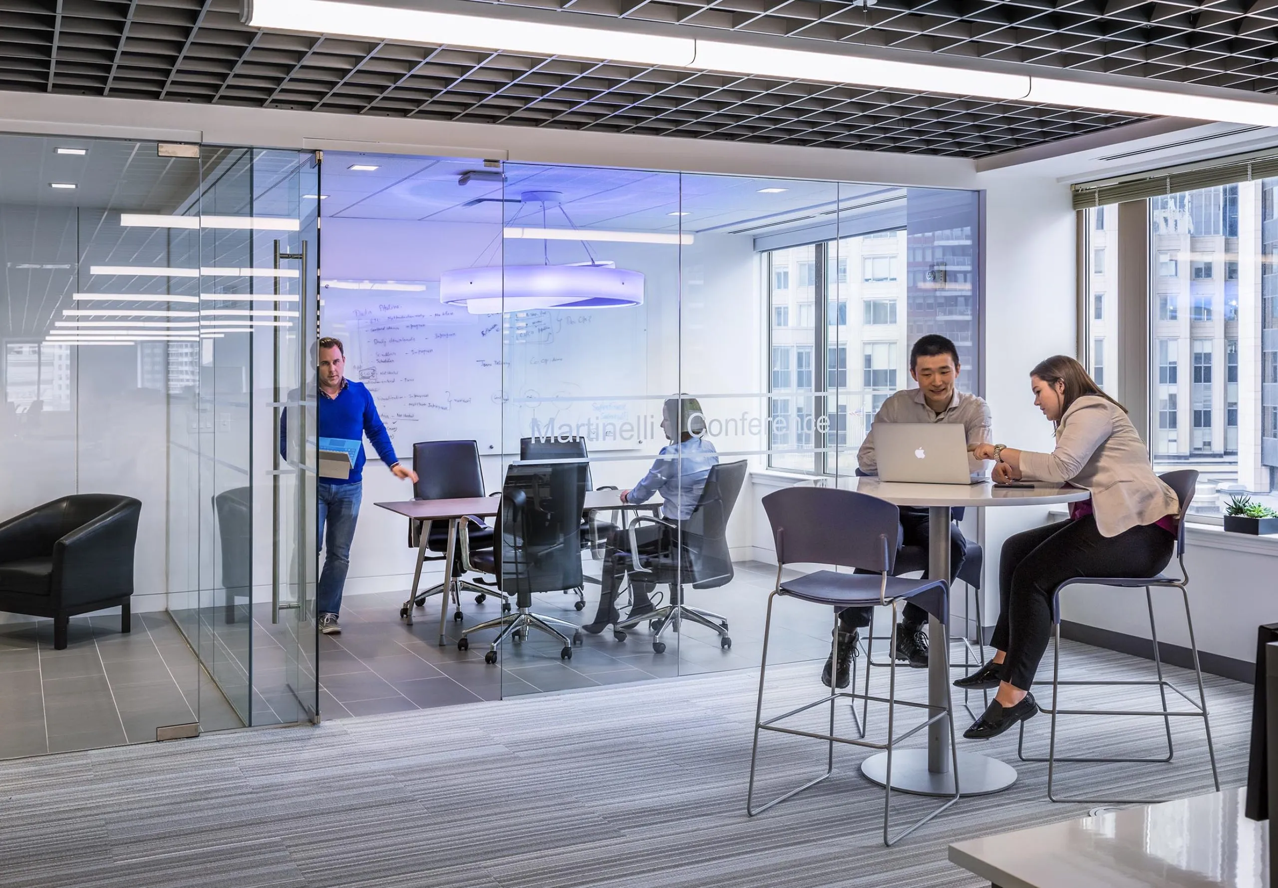 Communal seating and meeting rooms with glass walls in office building