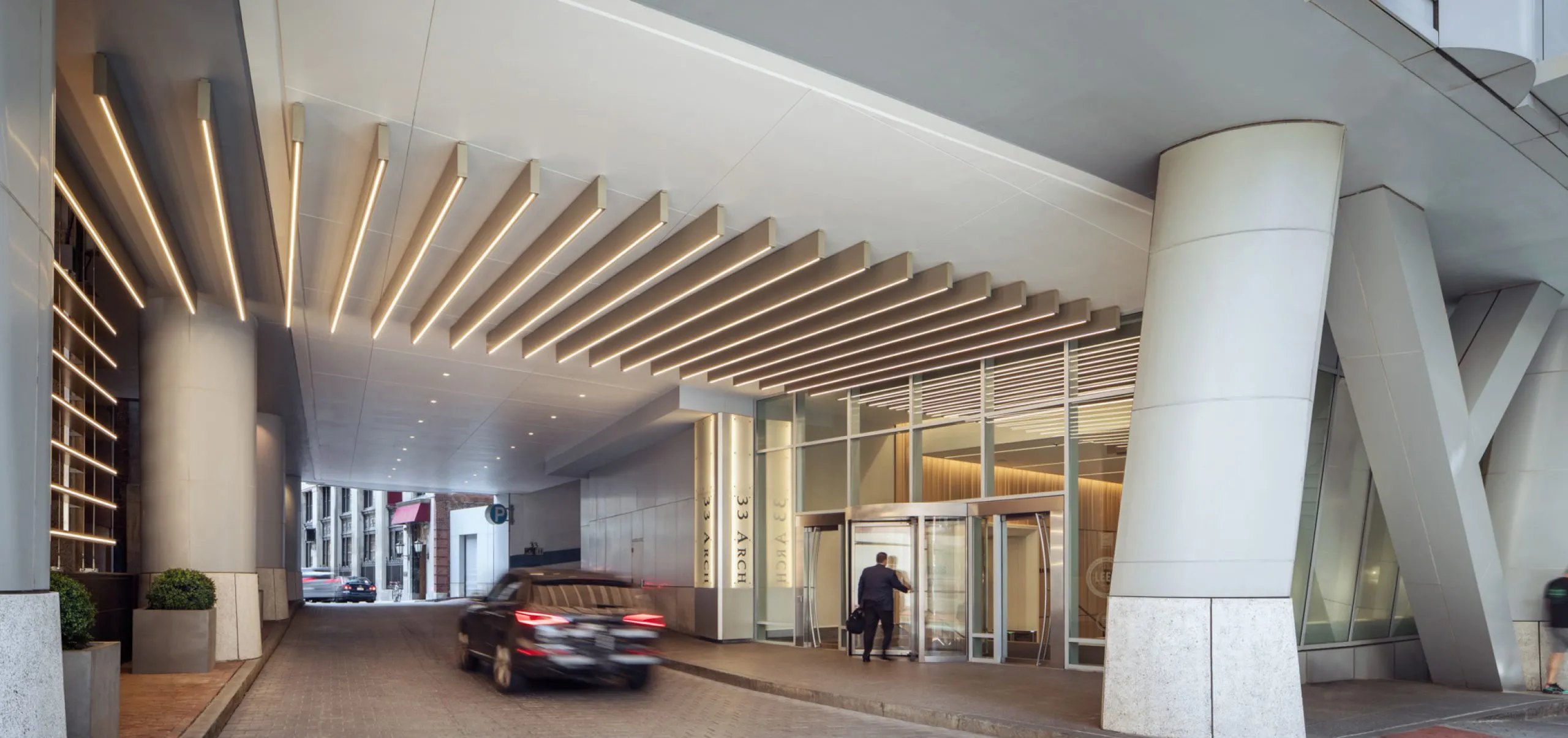 Cars driving on covered private road with entryway to office building