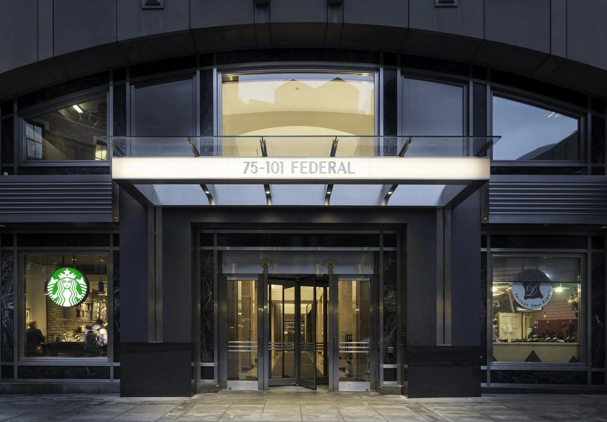 Exterior entry of apartment building with shops visible from front windows at 75-101 Federal street