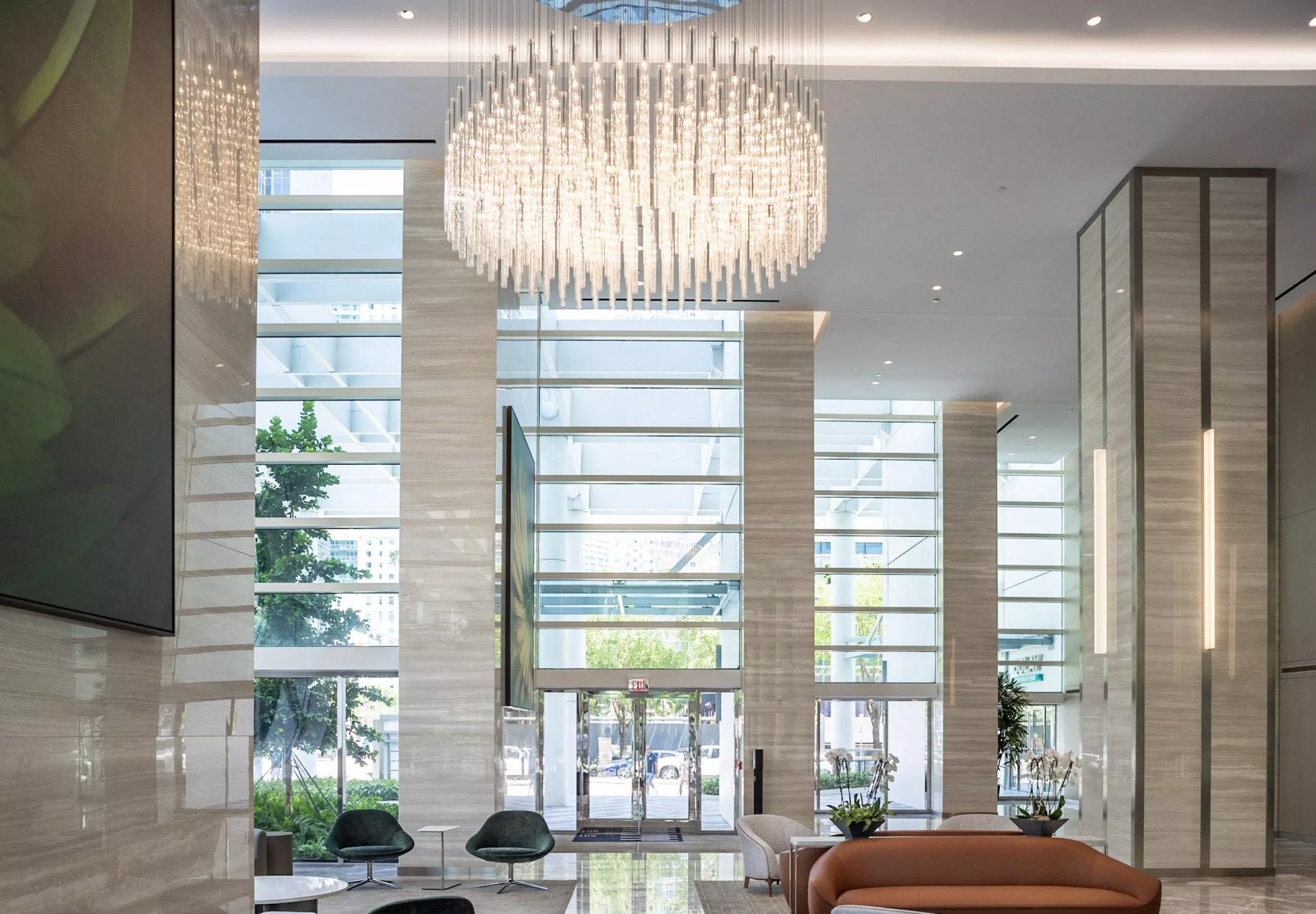 Modern upscale lobby with seating and large chandelier at 801 Brickell