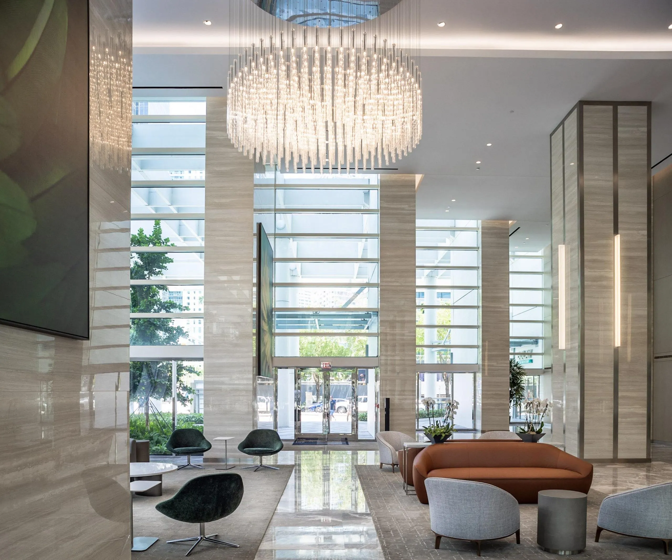 Modern upscale lobby with seating and large chandelier at 801 Brickell