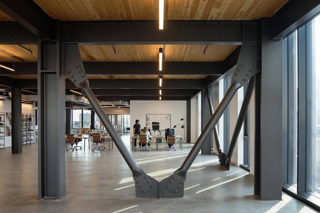 Interior view of office space with large industrial beams and wooden ceilings