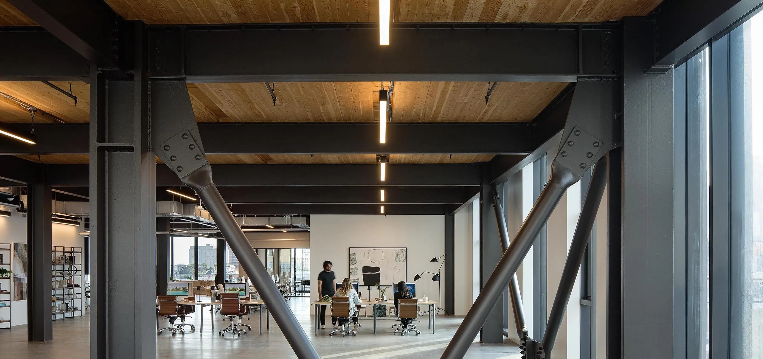 Interior view of office space with large industrial beams and wooden ceilings