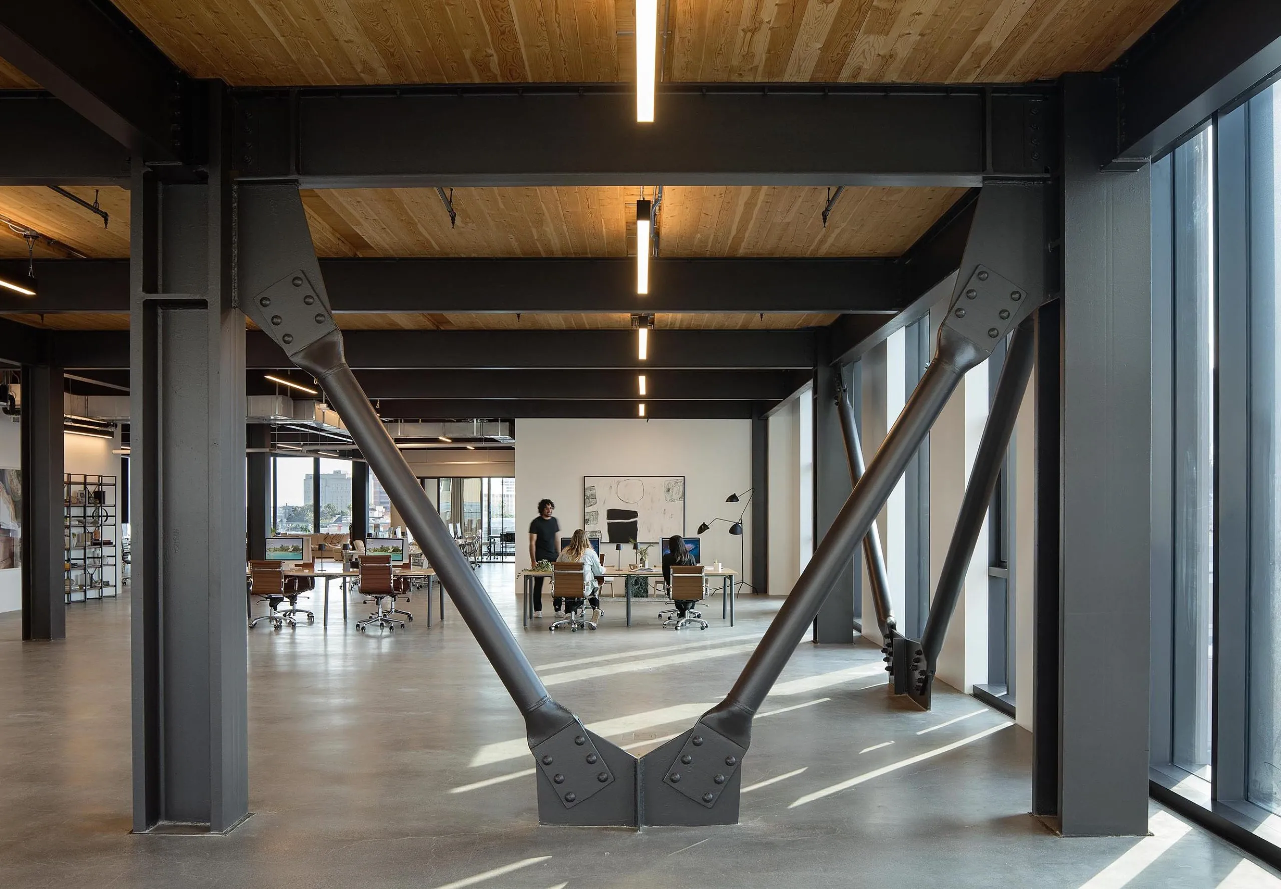 Interior view of office space with large industrial beams and wooden ceilings