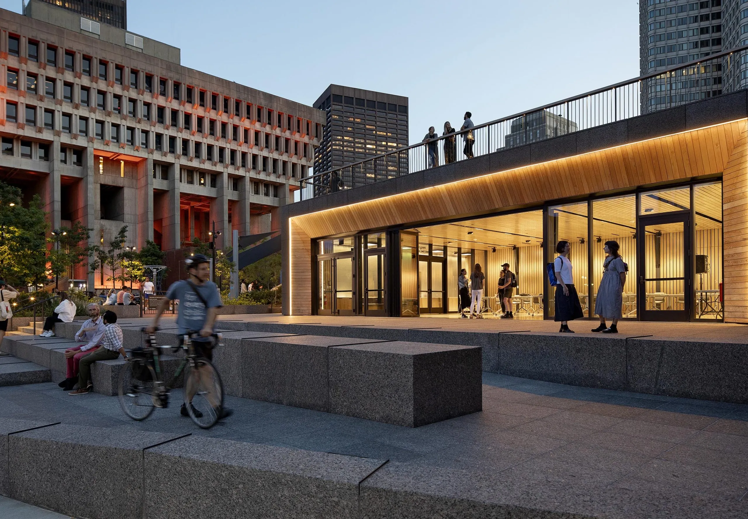 People sitting and walking in the plaza at the Boston City Hall