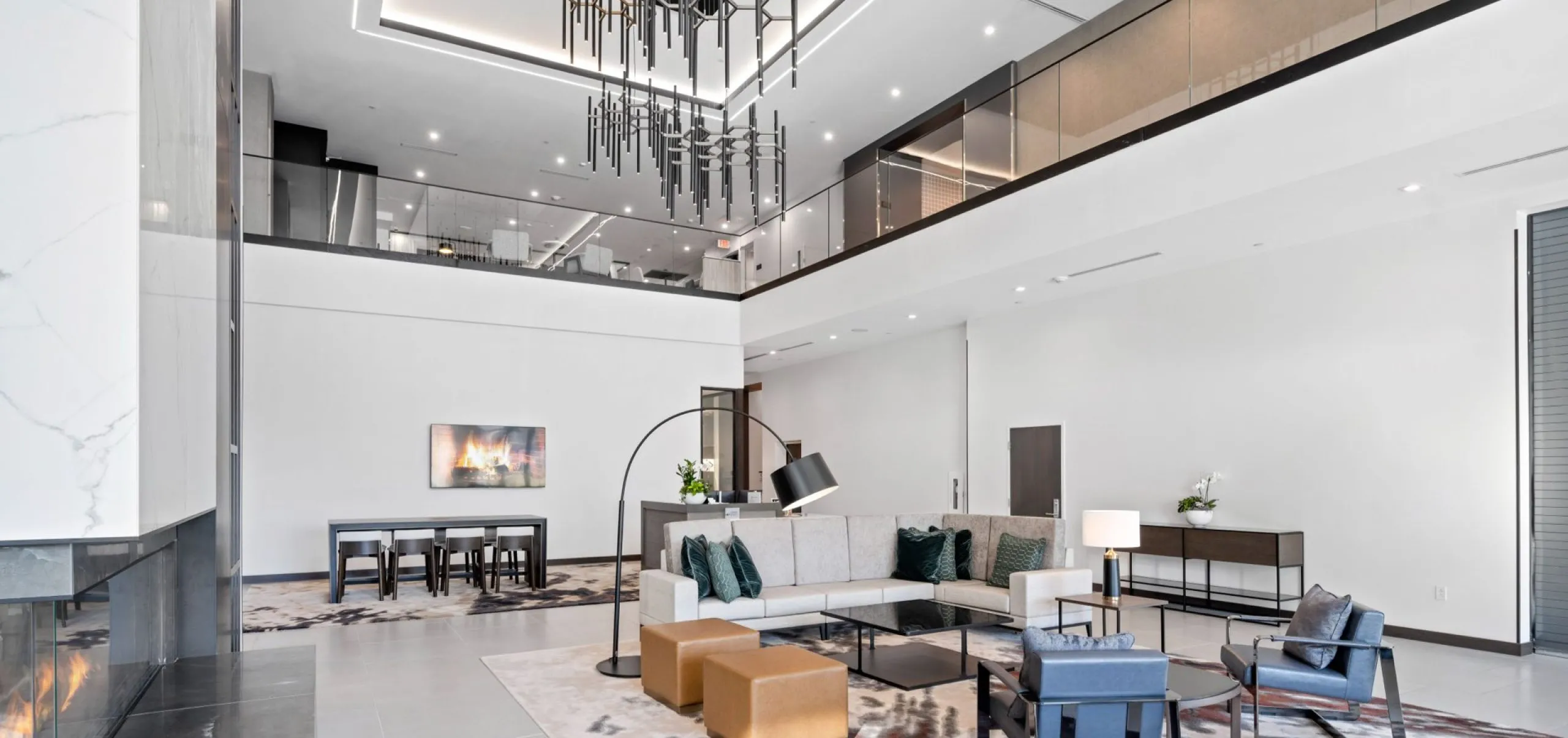 Modern communal indoor seating and dining room with fireplace at Emblem 125 apartment complex