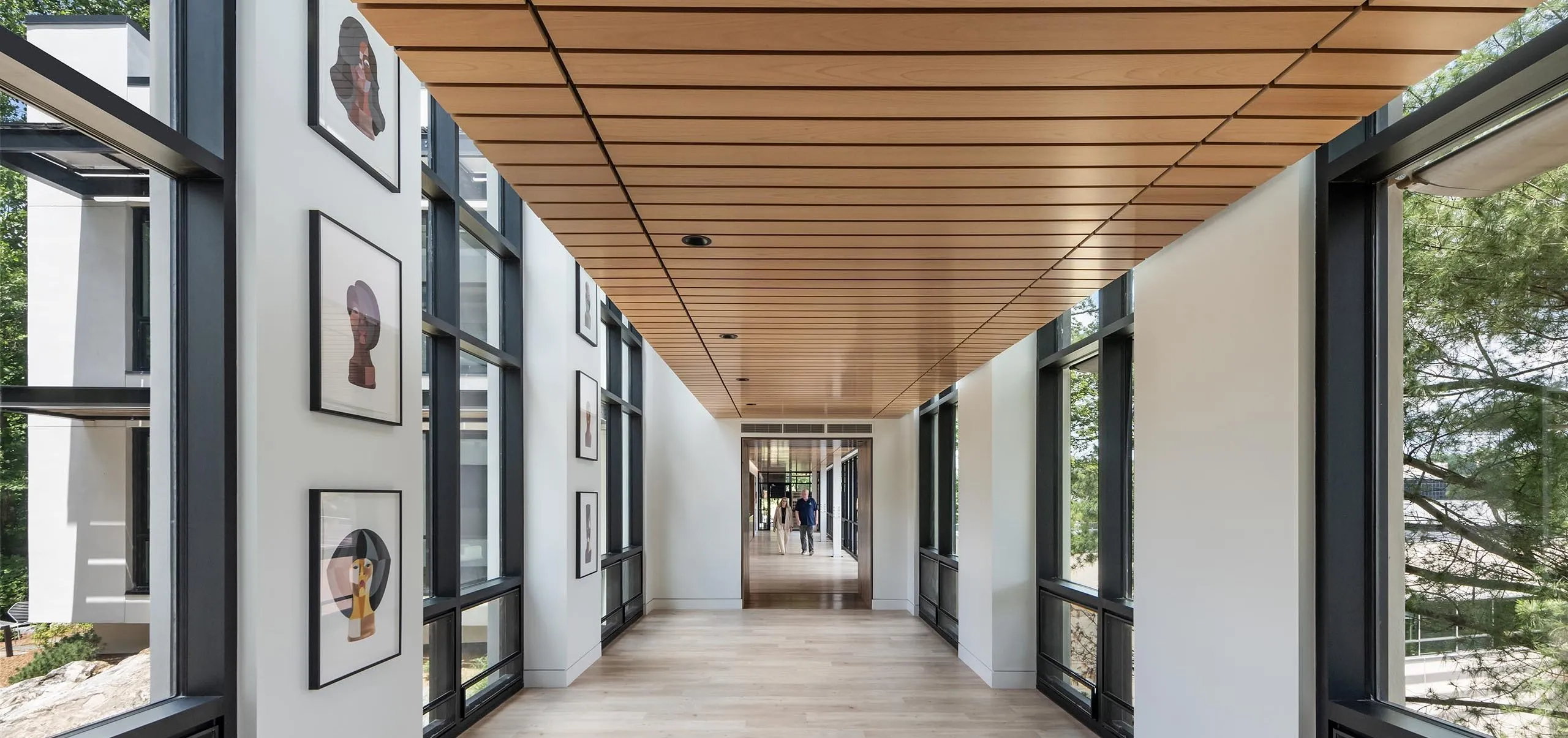 Long modern hallway with art on wall at HMTX Headquarters