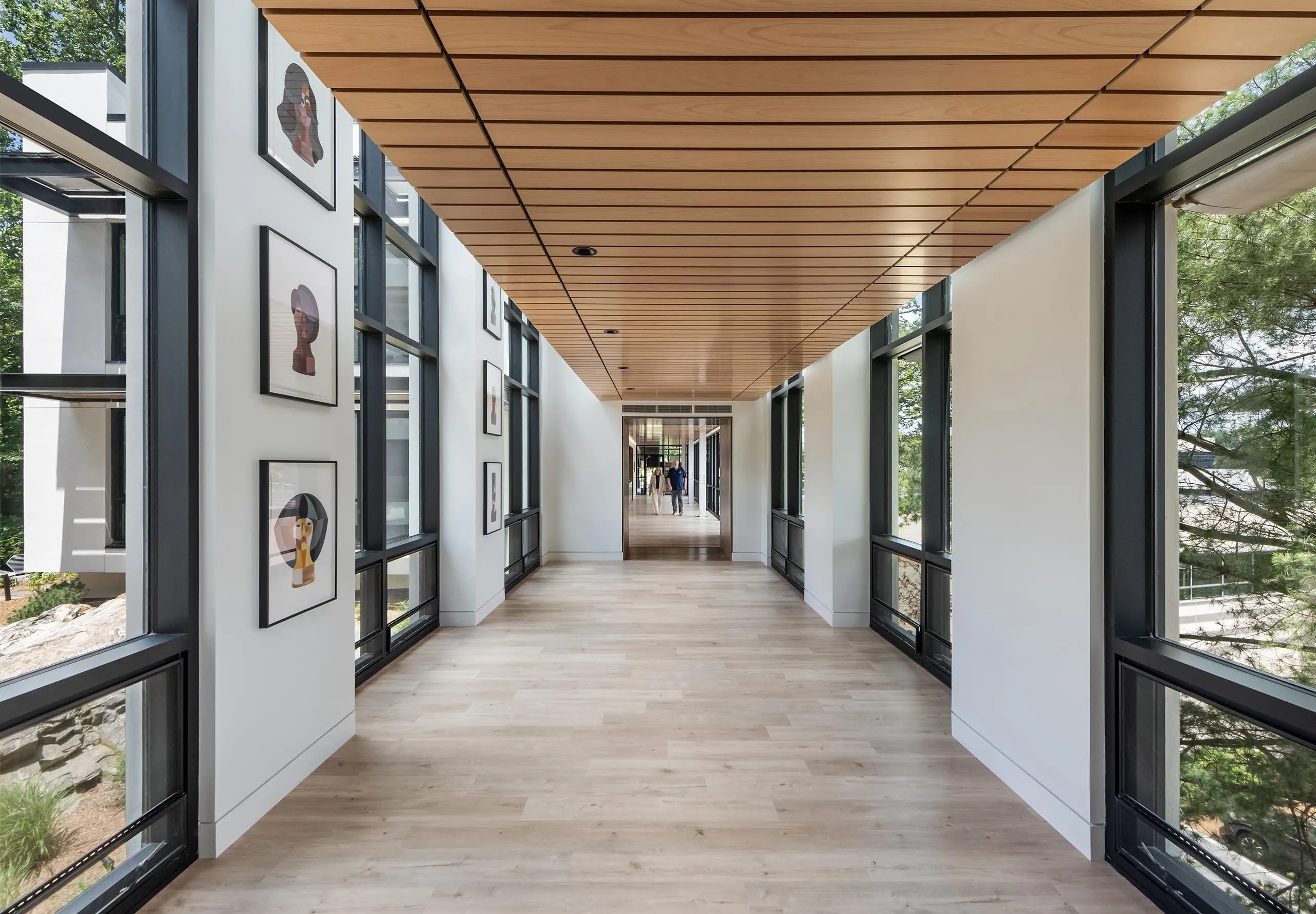 Long modern hallway with art on wall at HMTX Headquarters