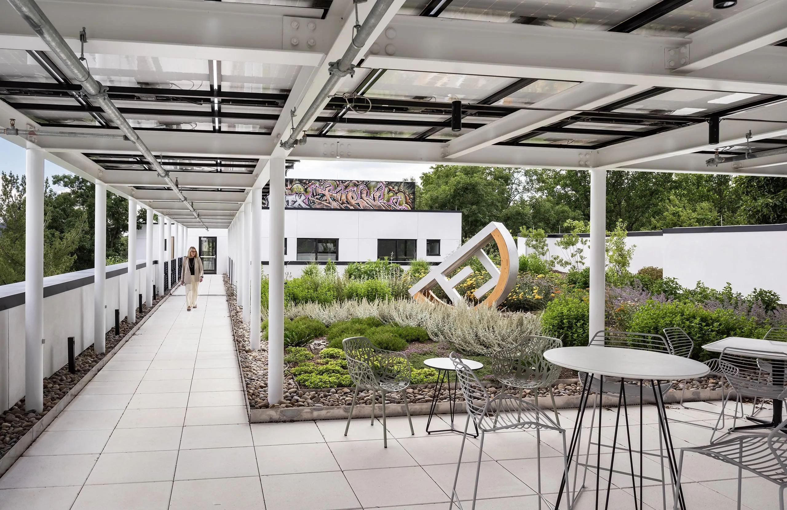 Outdoor garden with statue and covered seating at HMTX Headquarters