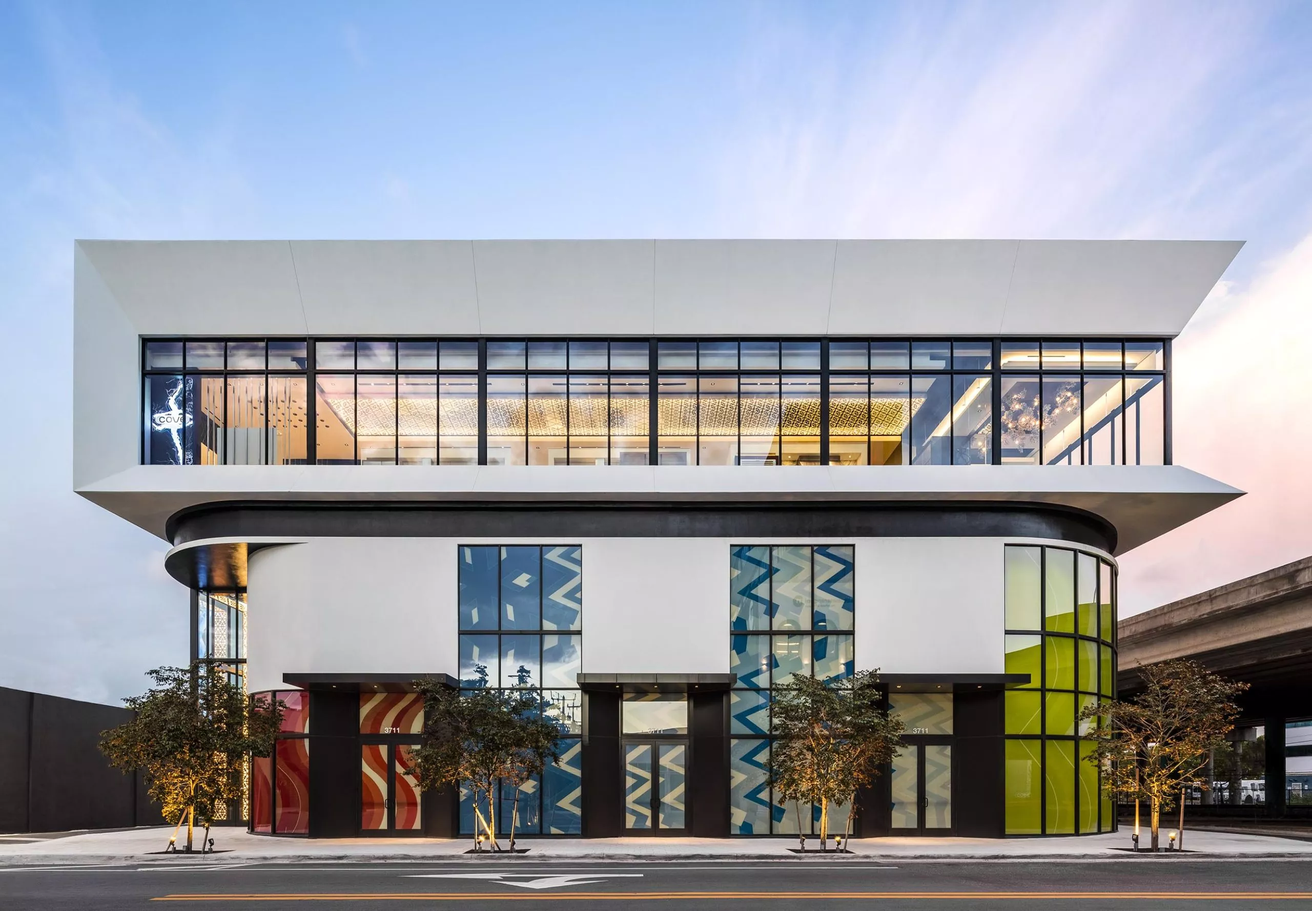 Street view with art visible in the windows at the Power Design Building