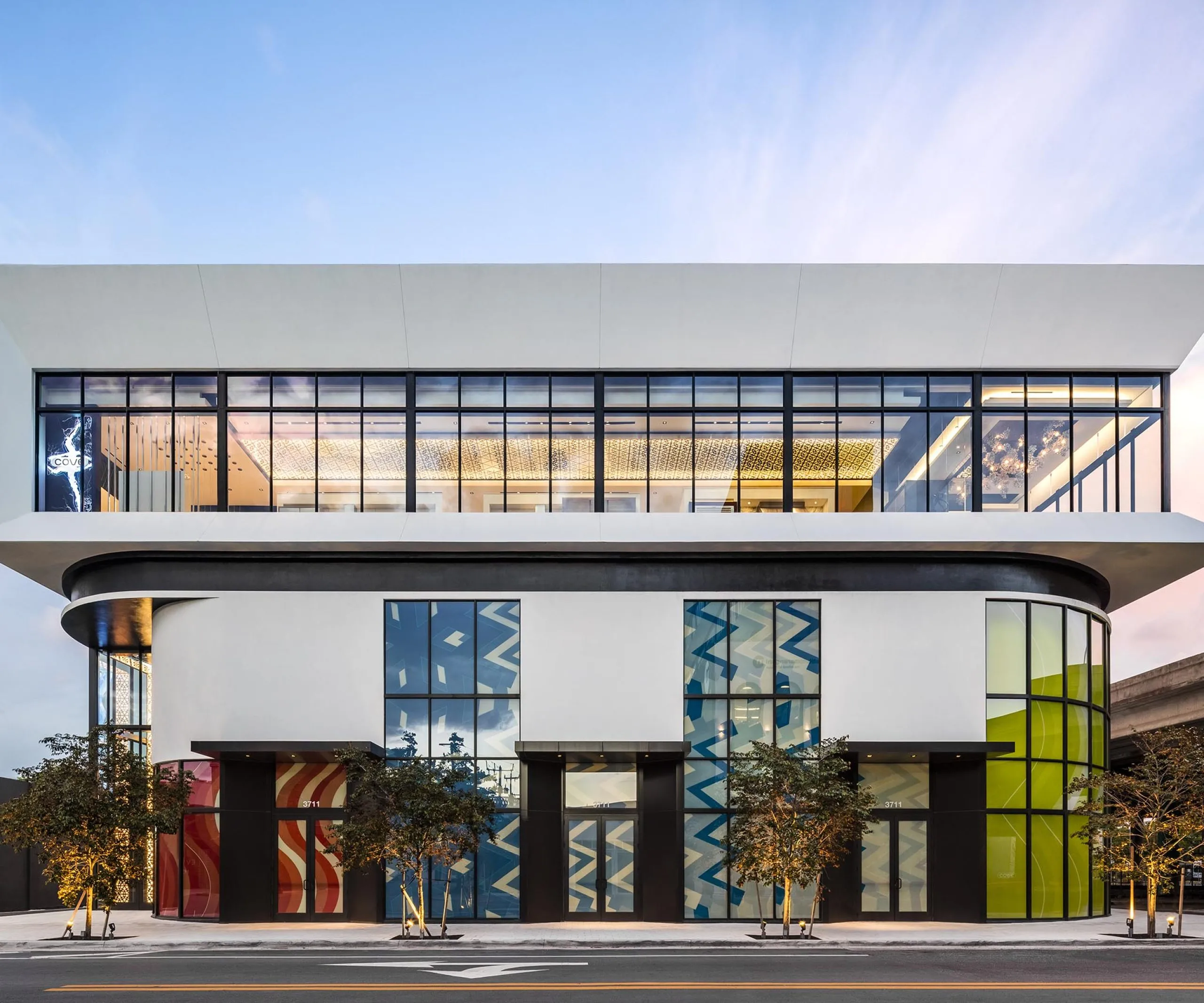 Street view with art visible in the windows at the Power Design Building