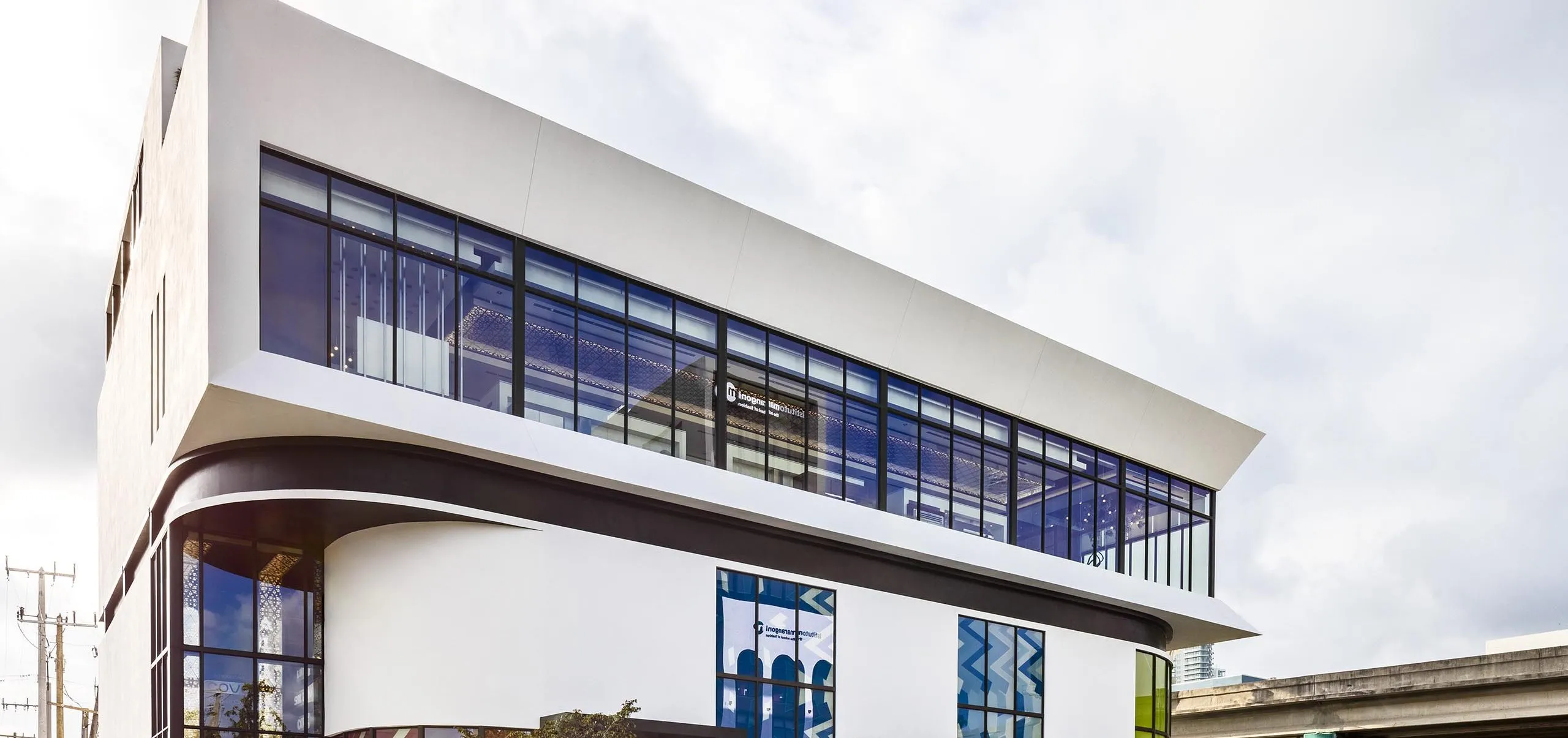 Street view with art visible in the windows at the Power Design Building