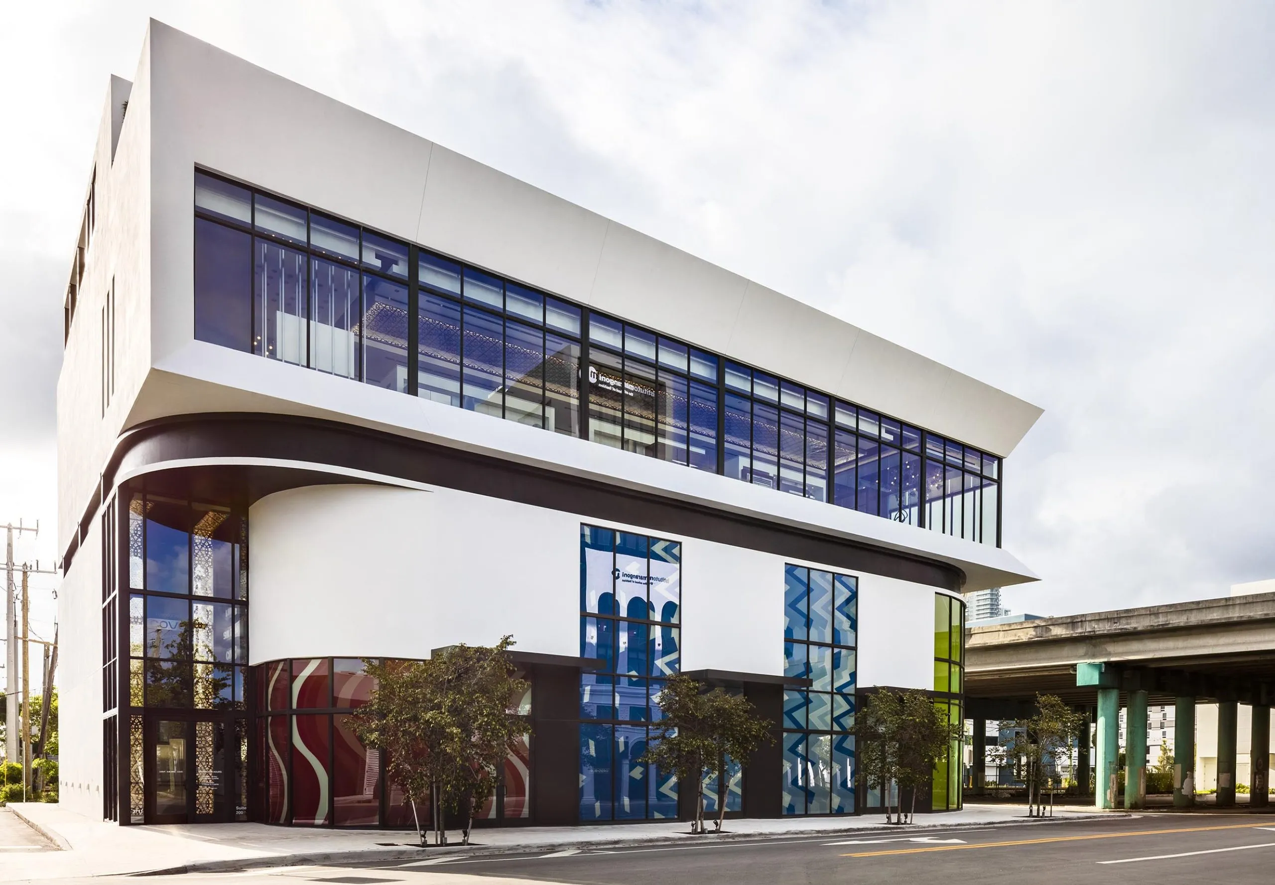 Street view with art visible in the windows at the Power Design Building