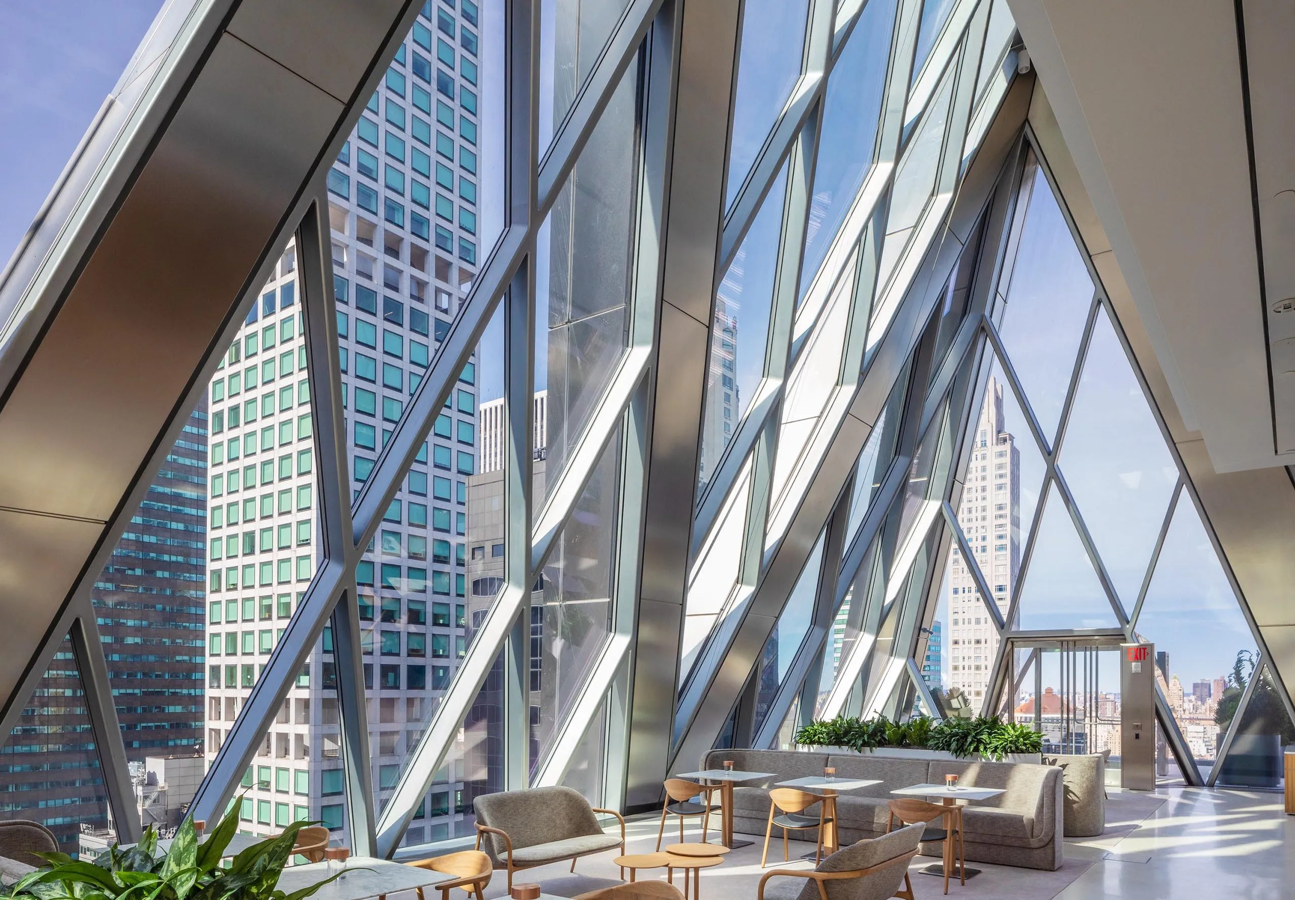 Dining and seating areas with large diamond windows at the Diagrid Club