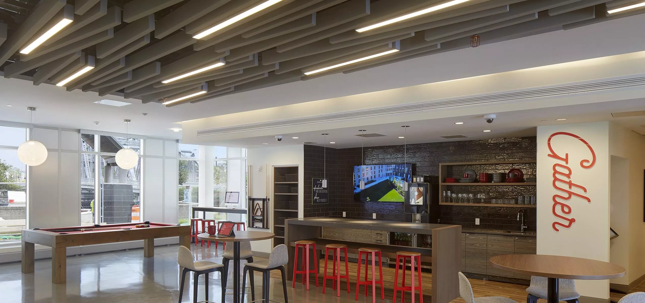 Communal dining space, kitchen and pool table at River House Aparatments