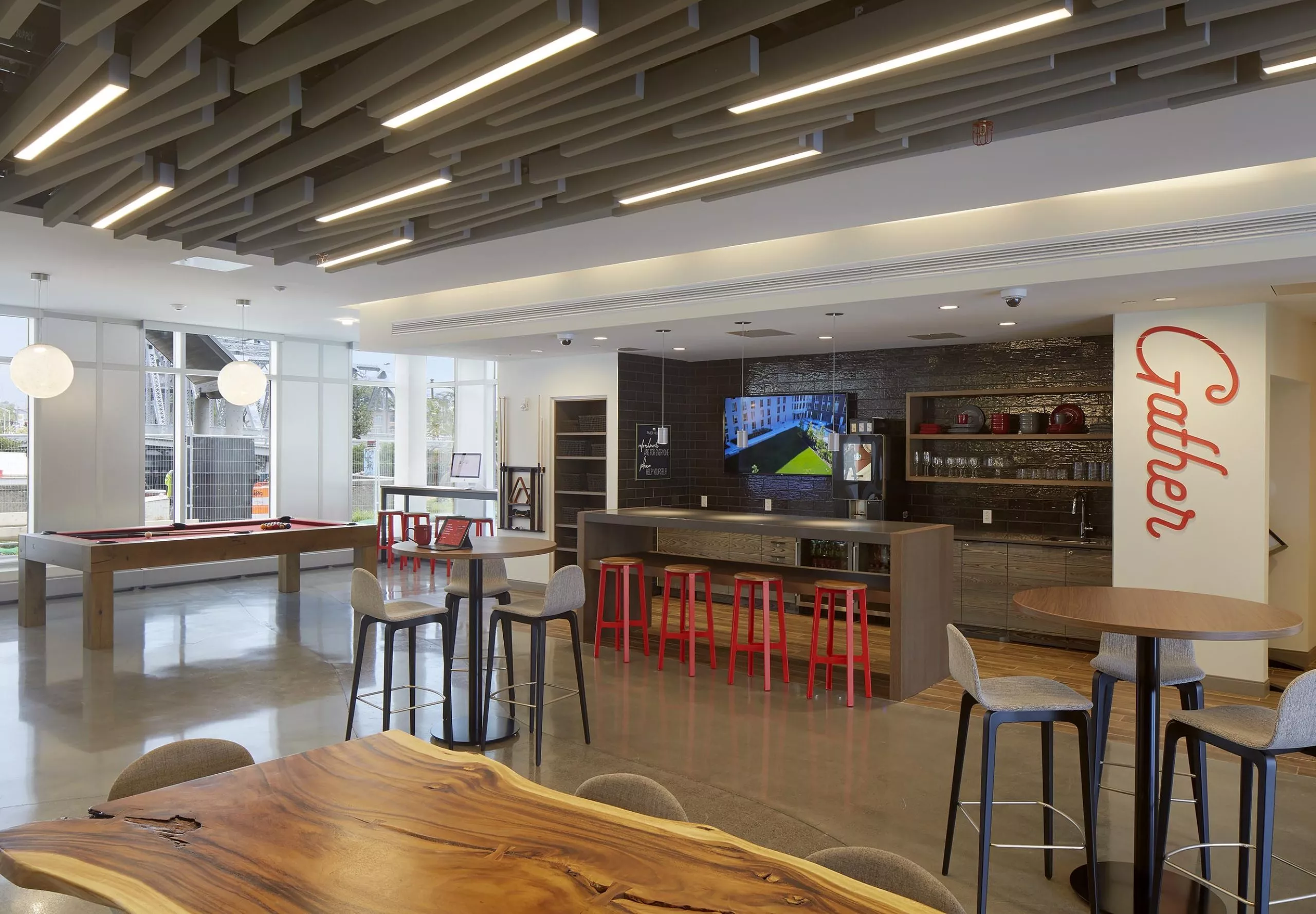 Communal dining space, kitchen and pool table at River House Aparatments