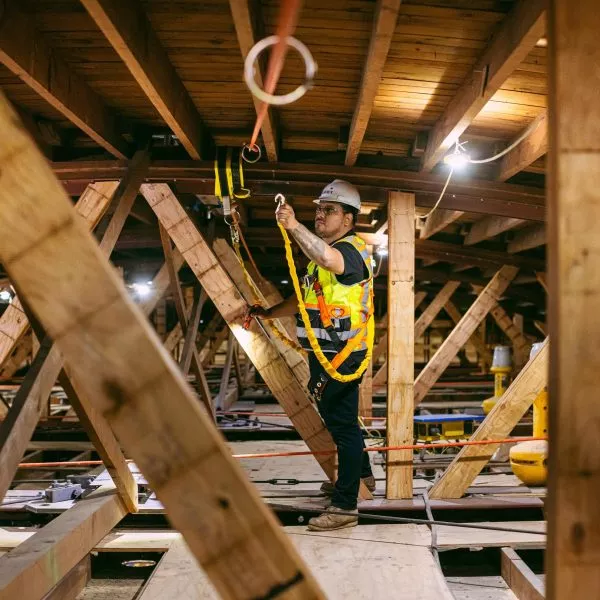 Shawmut employee working in the rafters of a building