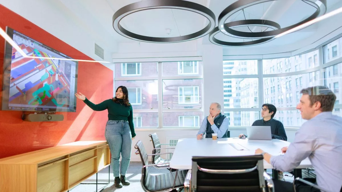 People in a meeting looking at building schematics