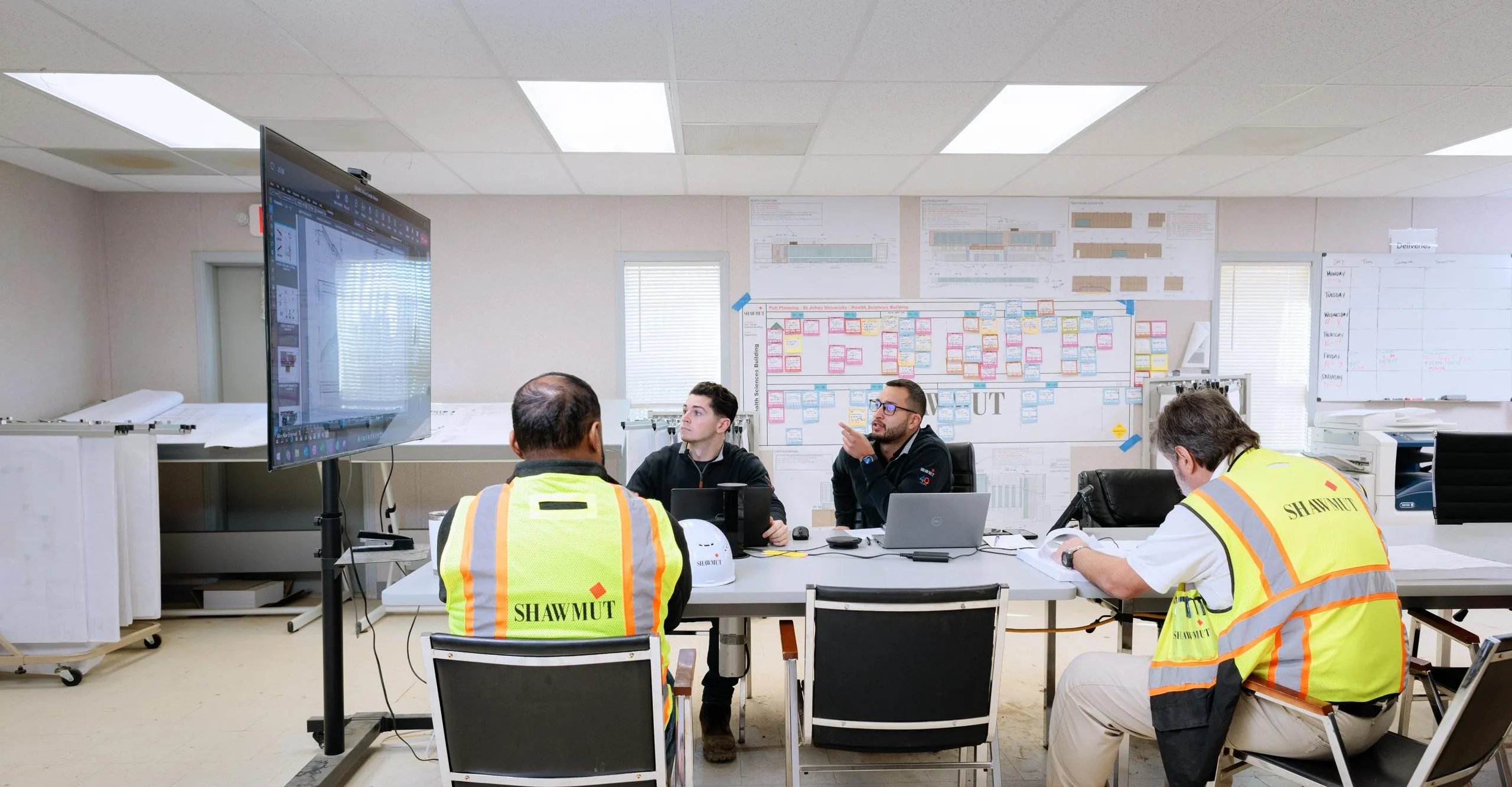 People around a table looking at building schematics