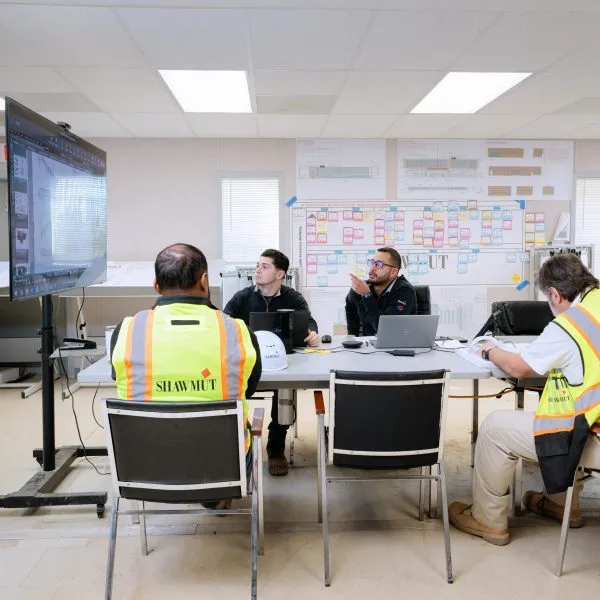 People around a table looking at building schematics