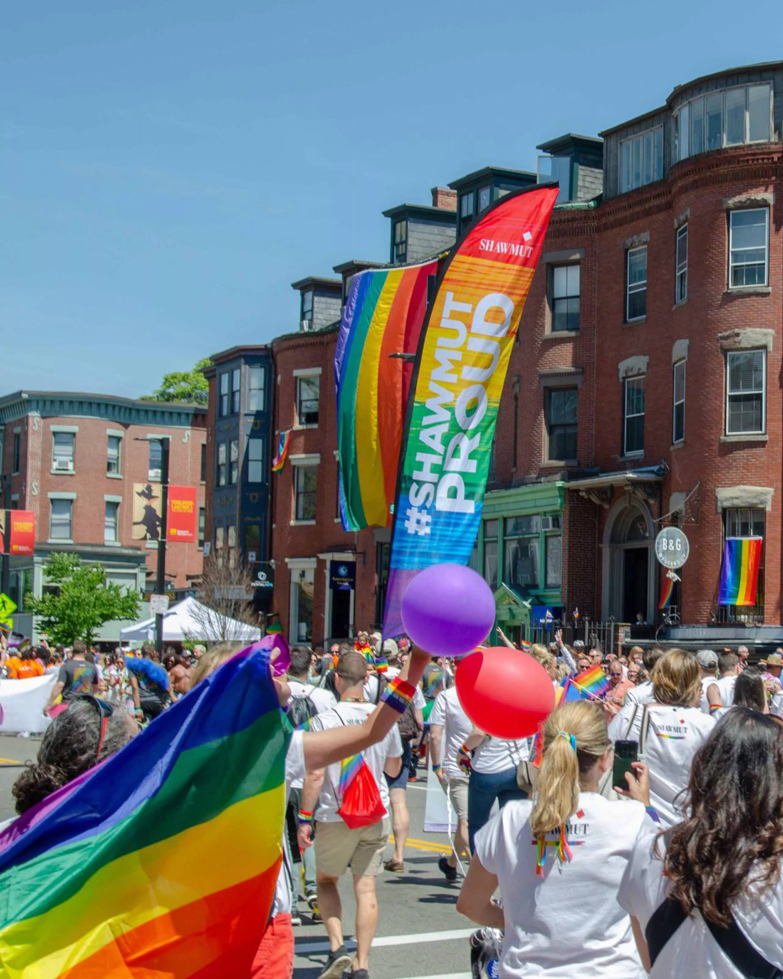 Shawmut at a pride festival with a sign that says #ShawmutProud