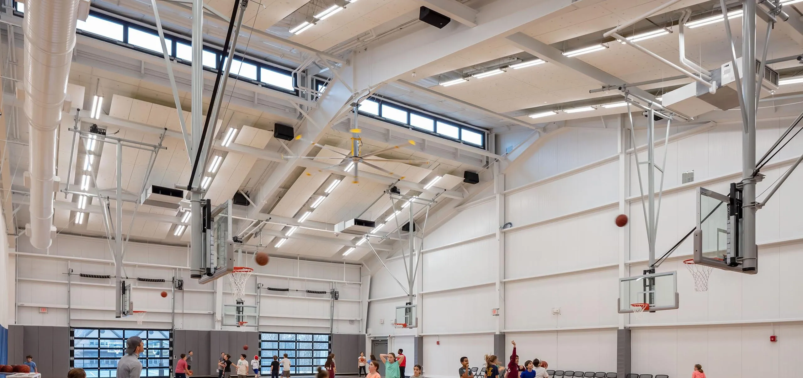 Children playing basketball in gym at Belmont Day School