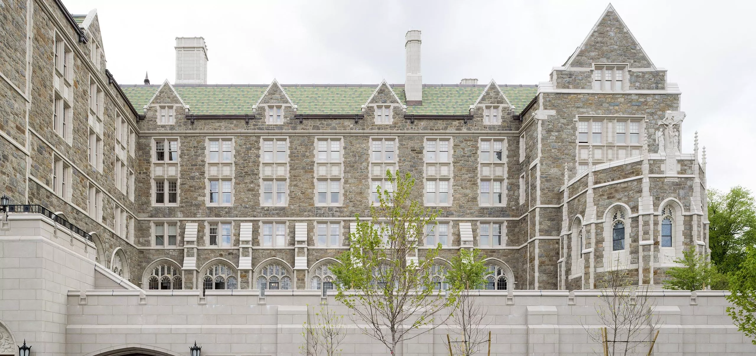 a large building with a green lawn and a tree