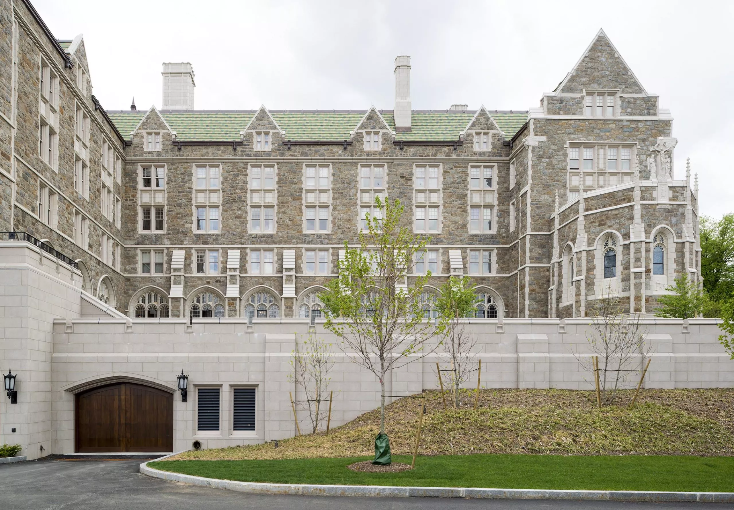 a large building with a green lawn and a tree