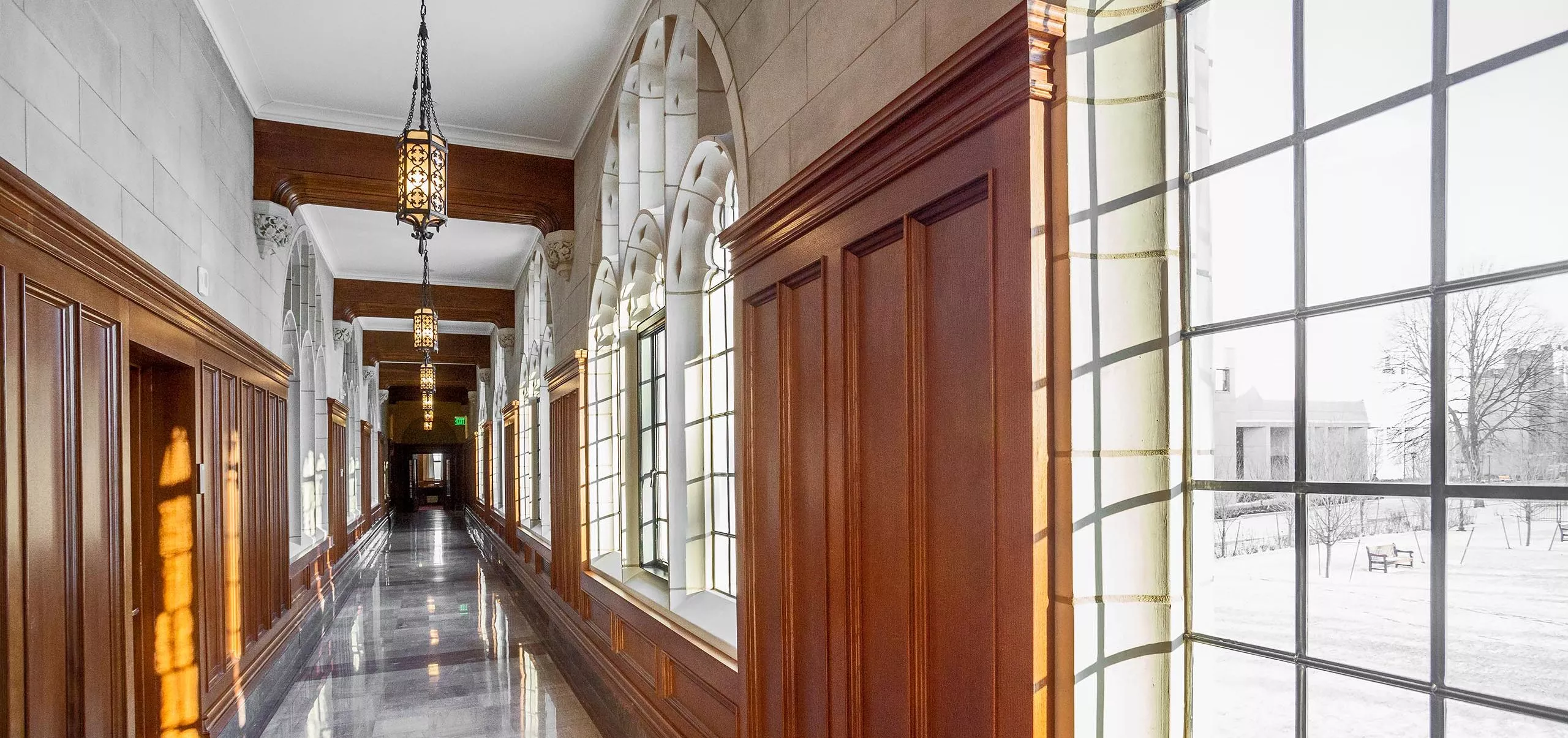 a long hallway with windows and wood paneling