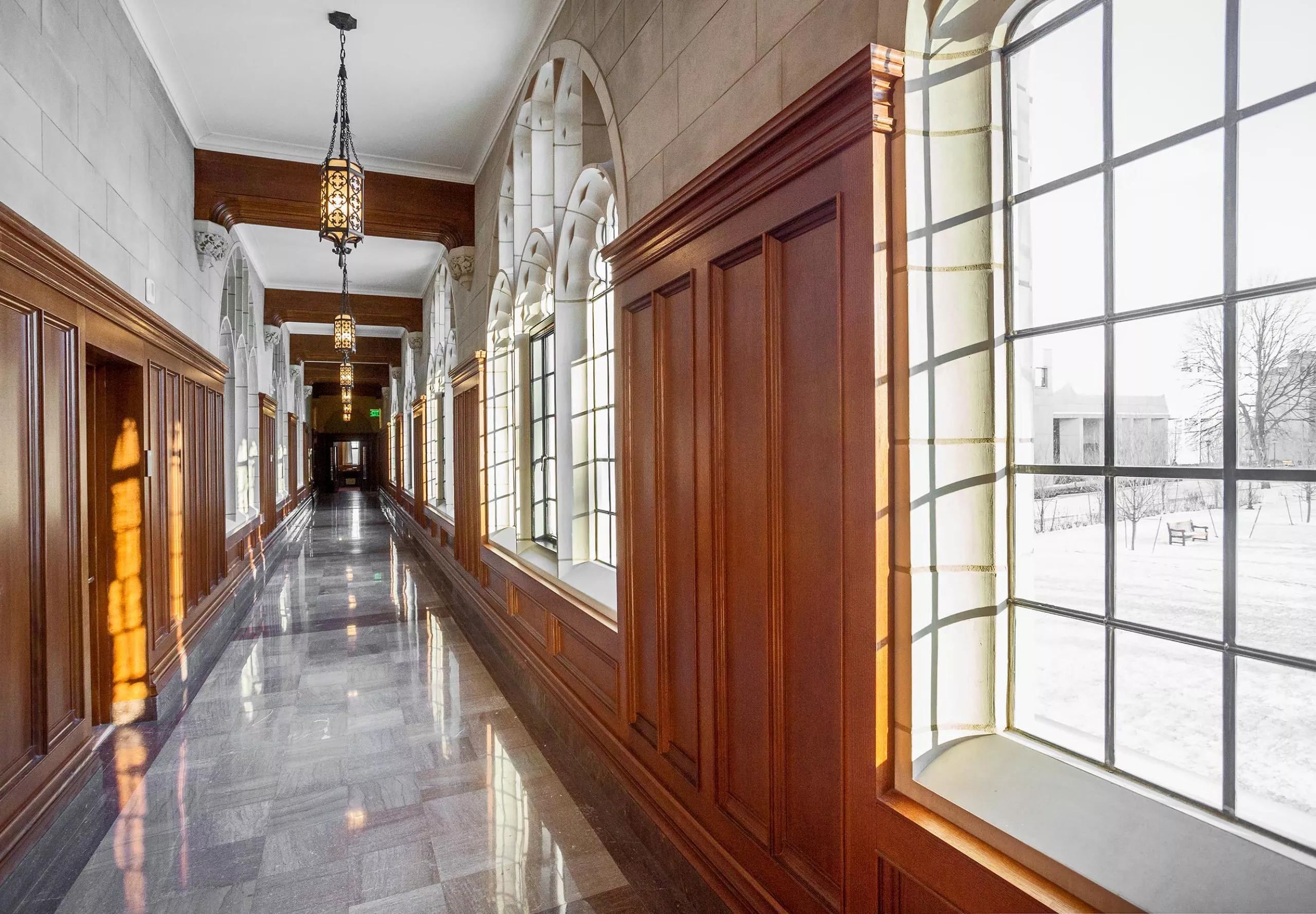 a long hallway with windows and wood paneling