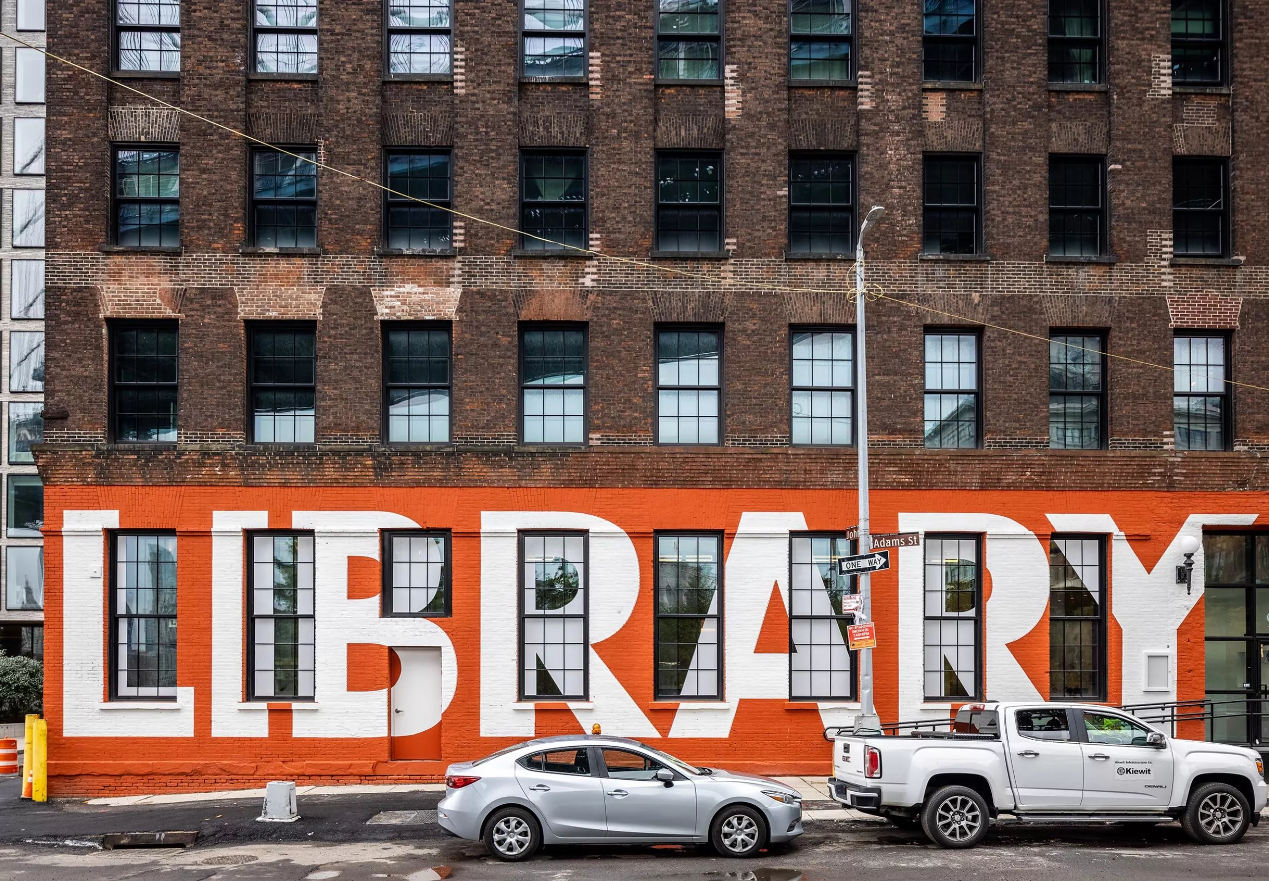 Exterior wall of Adams Street Library with a mural of the word Library on the wall