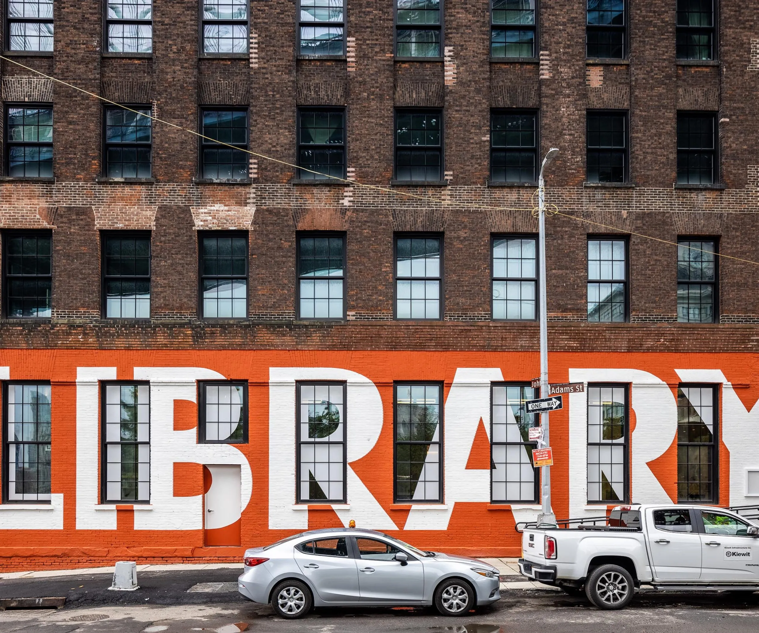 Exterior wall of Adams Street Library with a mural of the word Library on the wall