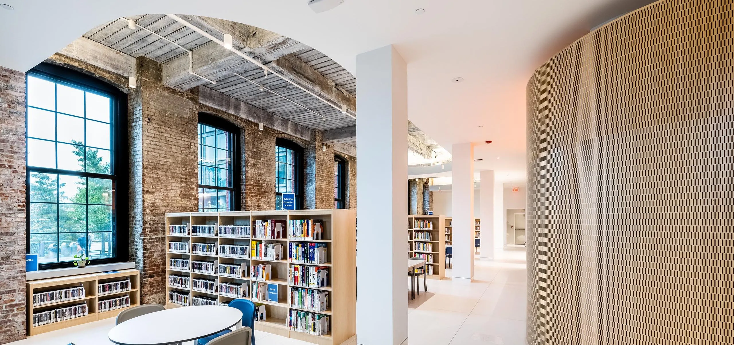 Modern and brick interior of Adams Street Library with bookshelves and children's seating