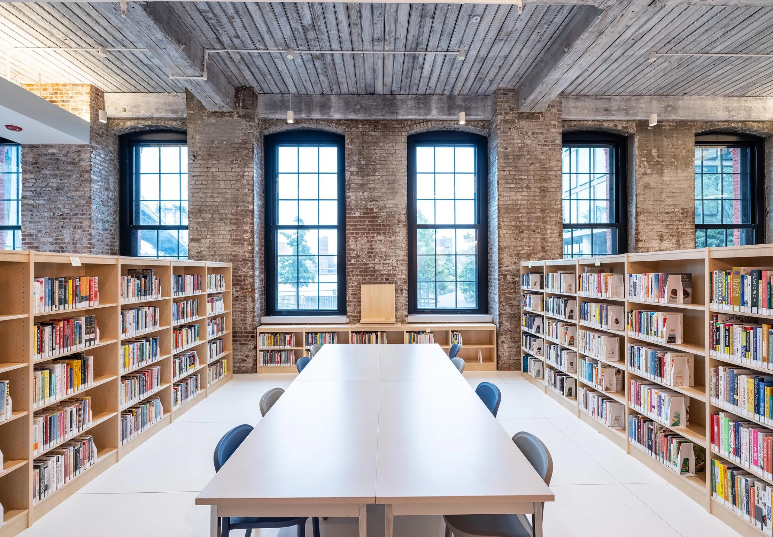 Bookshelves and a large table at the Adams Street Library