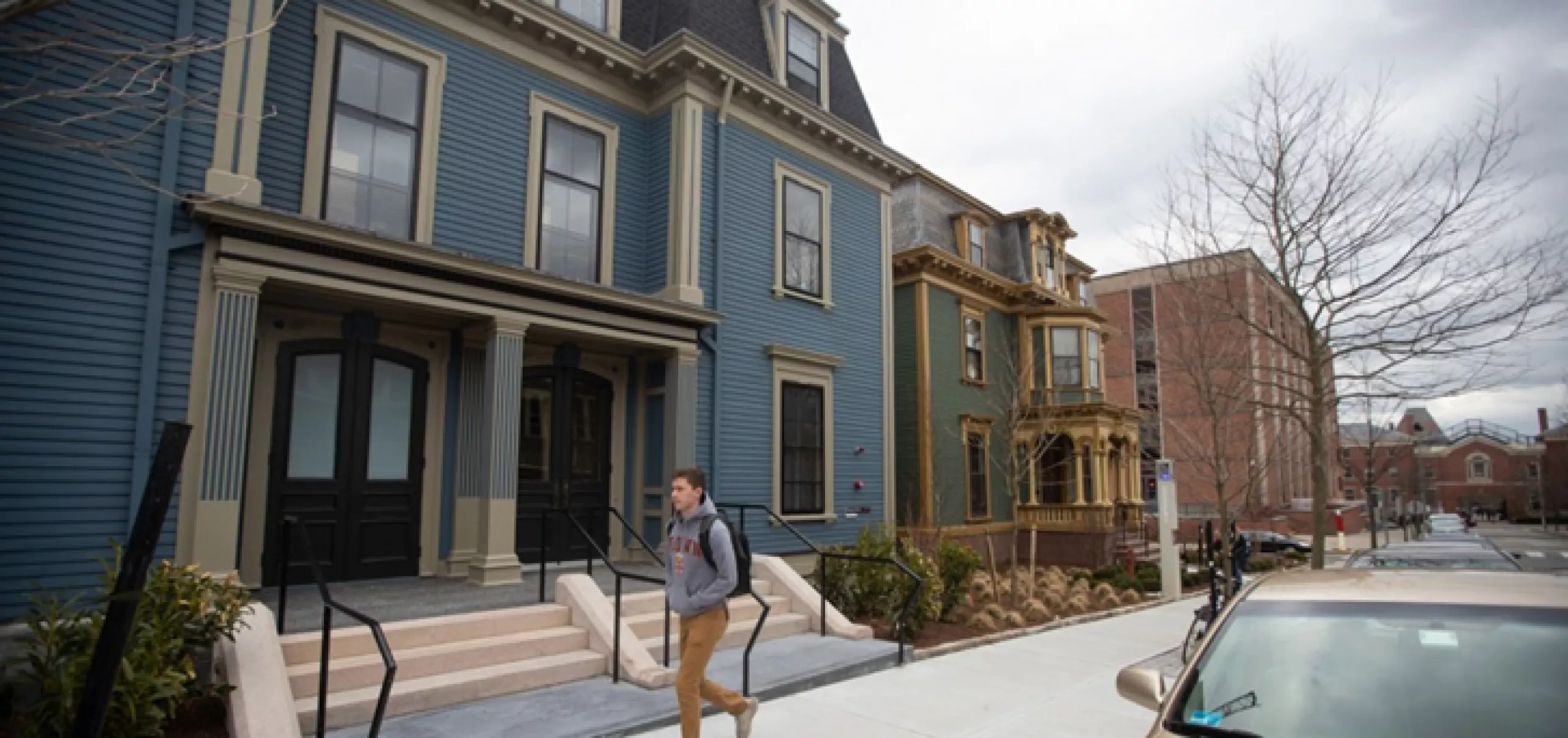 student walking outside in front of houses