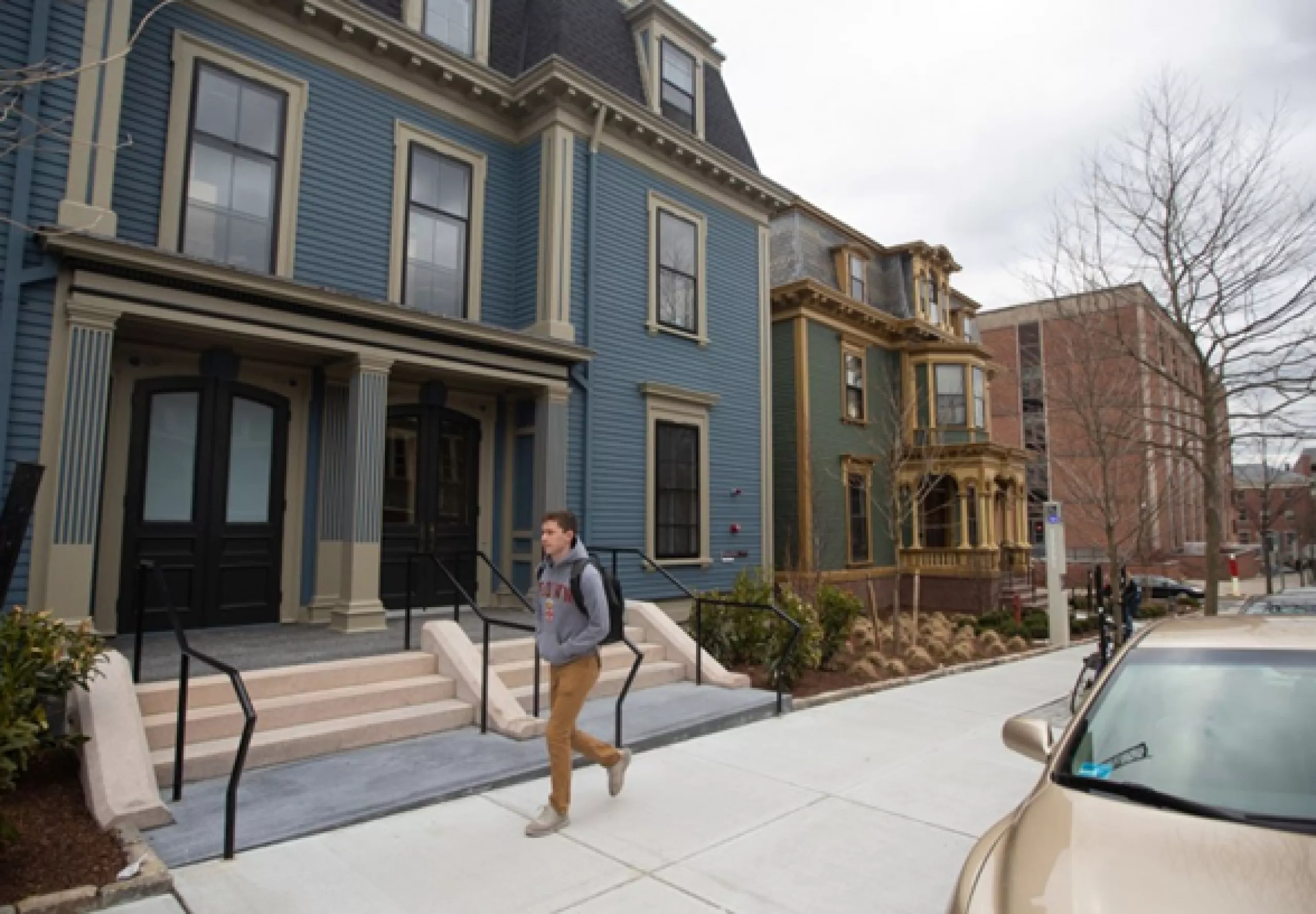 student walking outside in front of houses