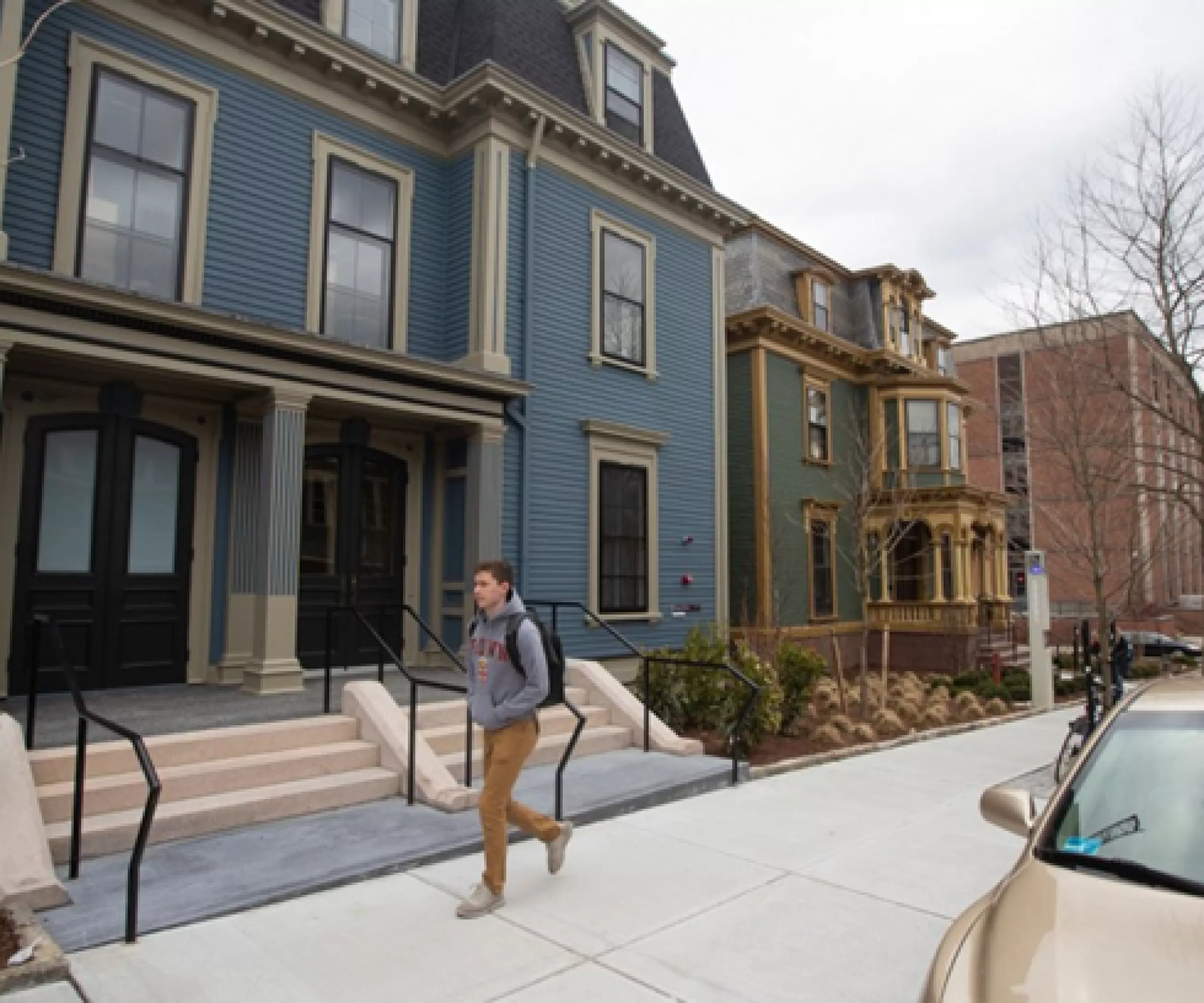 student walking outside in front of houses