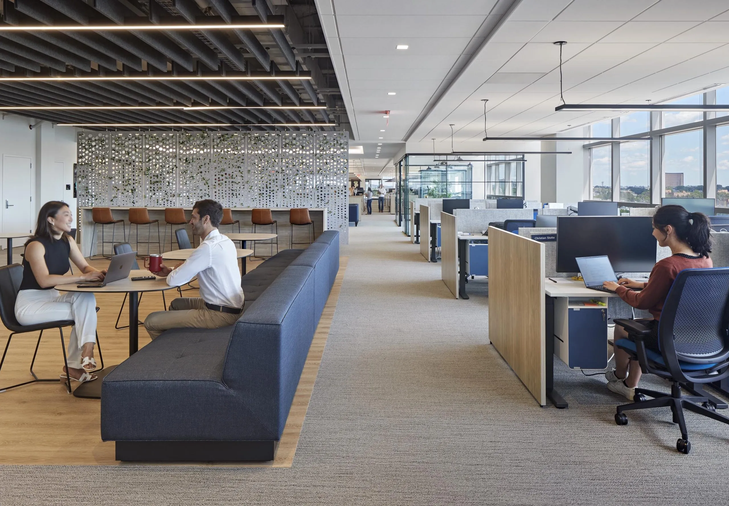 interior view of office work spaces with employees sitting at a table working