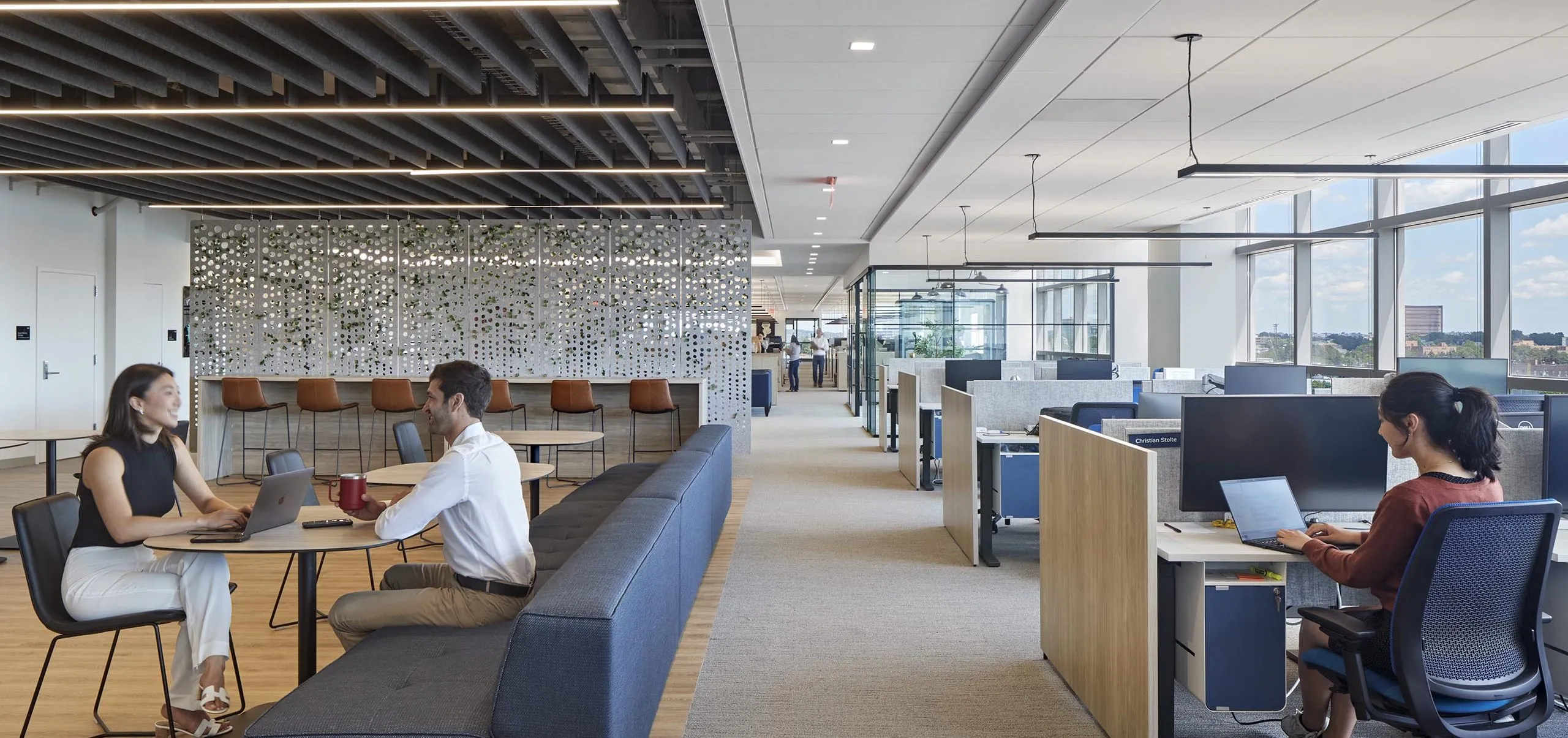 interior view of office work spaces with employees sitting at a table working