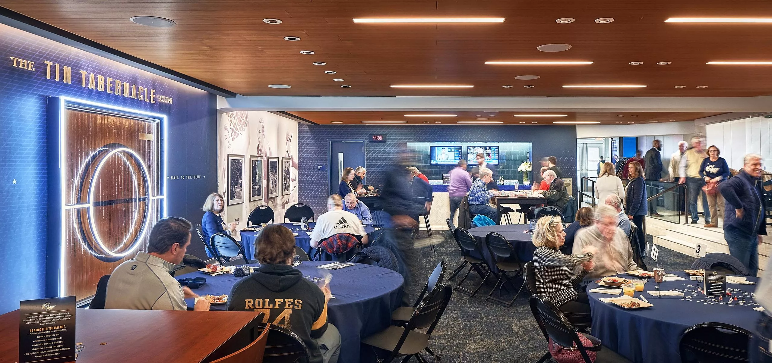 People sitting at tables in the Tin Tabernacle Club at the Charles E Smith Center