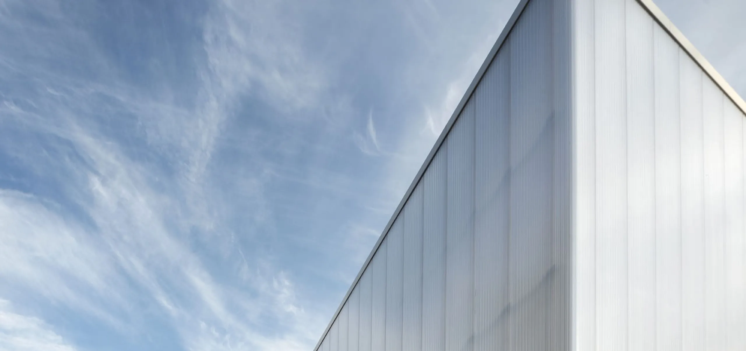 People walking outside of white modern exterior of Glorya Kaufman Performing Arts Center