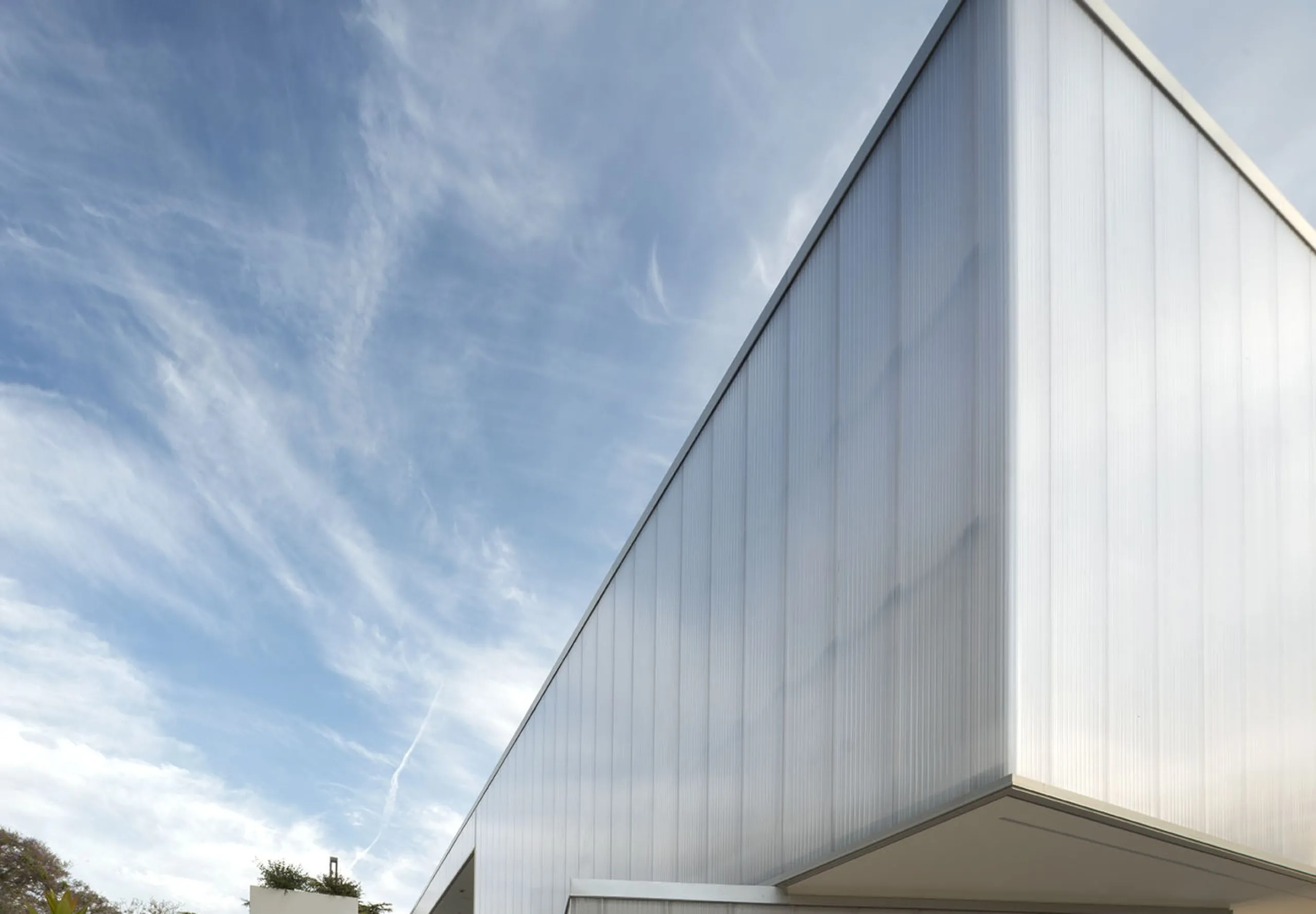 People walking outside of white modern exterior of Glorya Kaufman Performing Arts Center