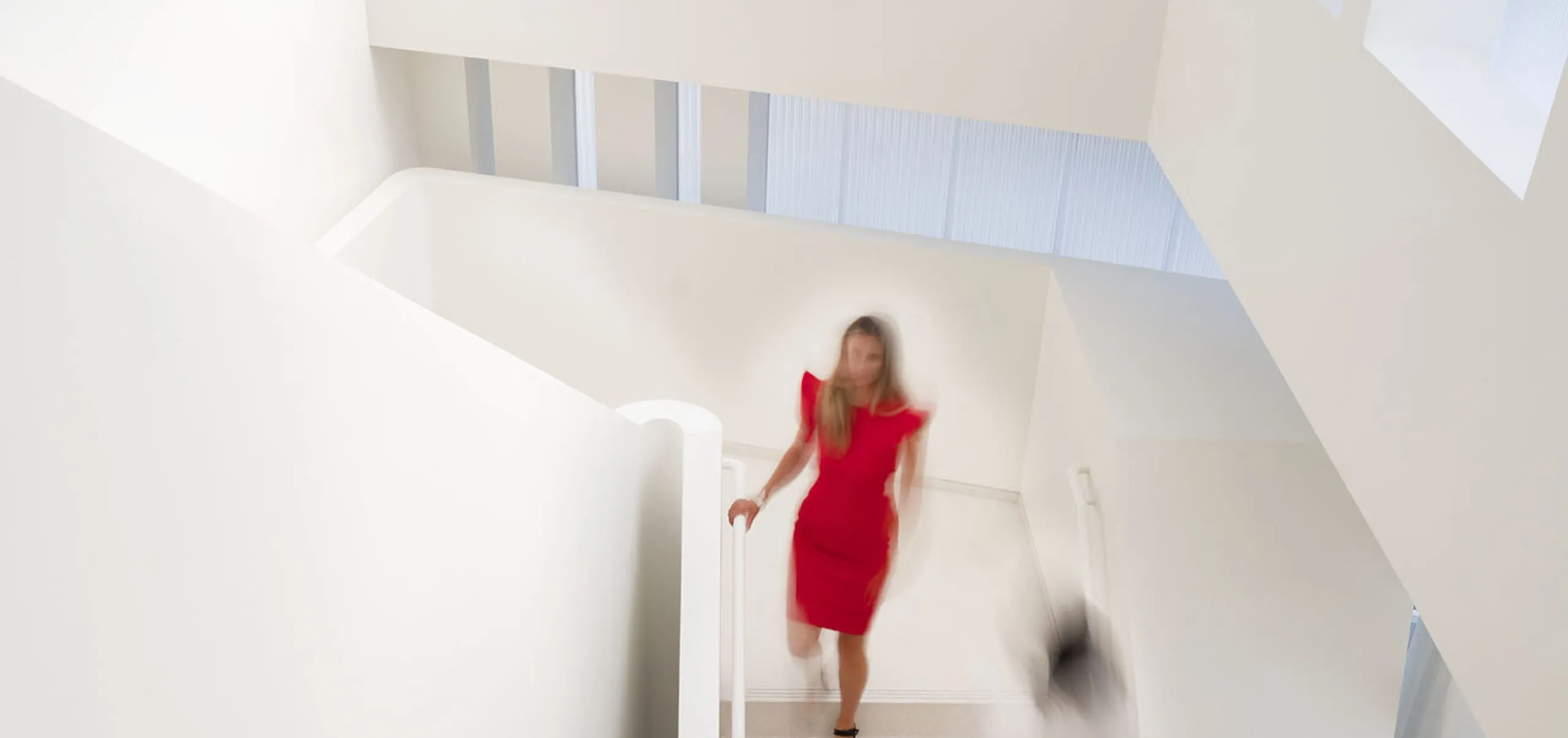 People walking down all white staircase at Glorya Kaufman Performing Arts Center