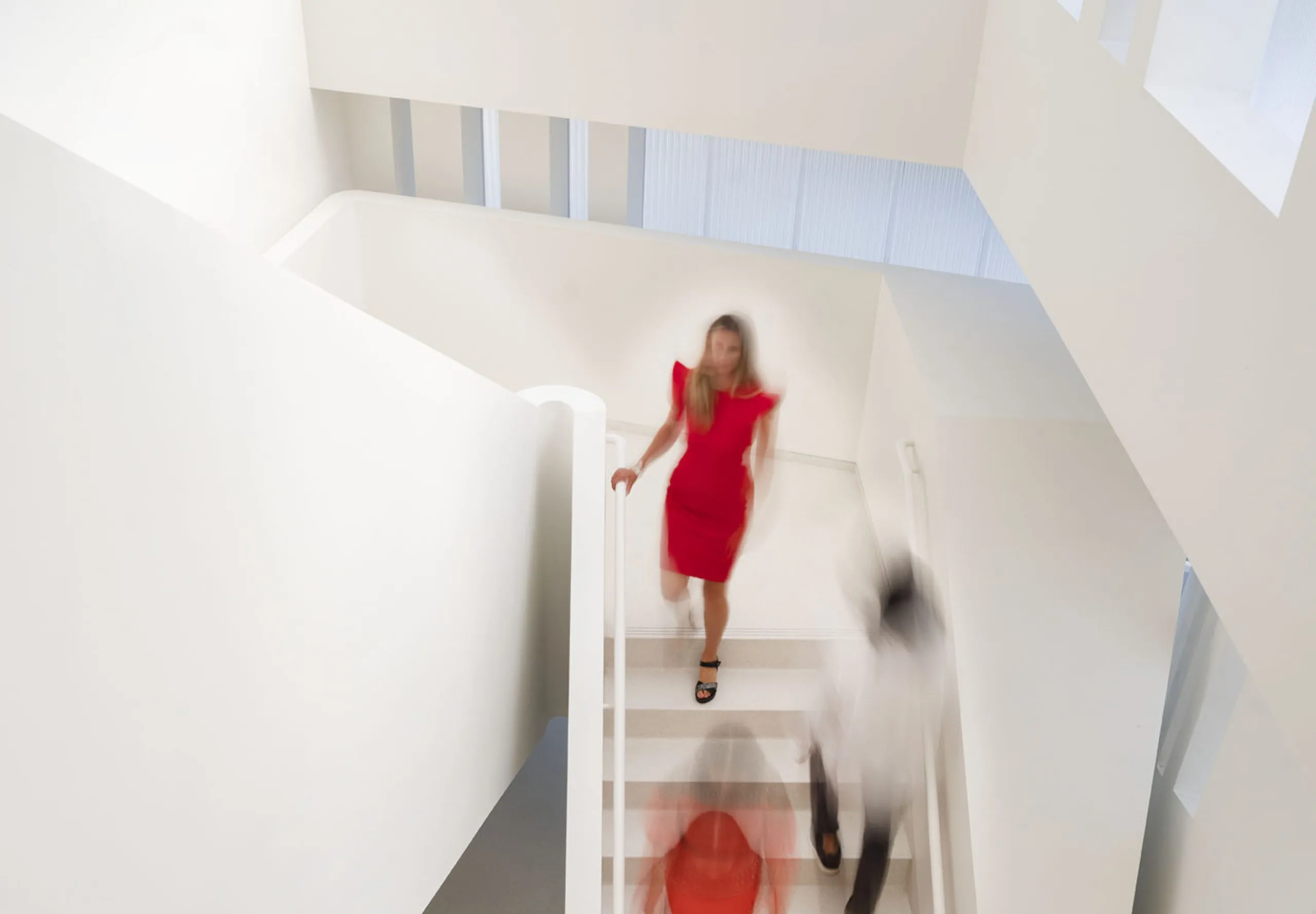 People walking down all white staircase at Glorya Kaufman Performing Arts Center