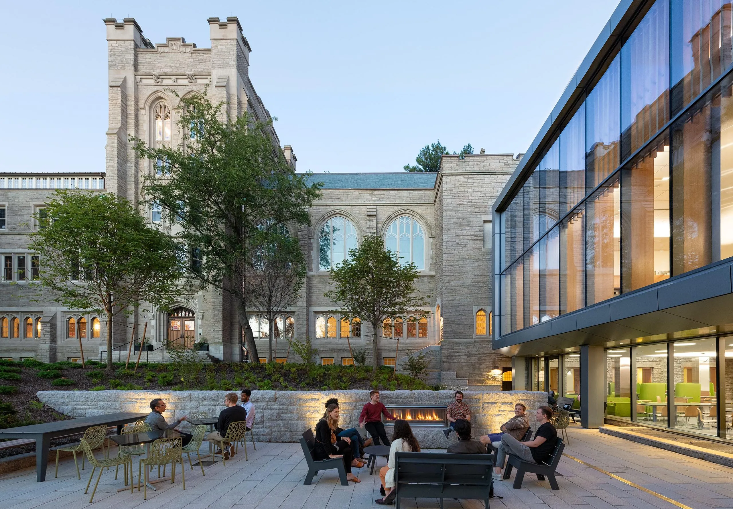 People sitting in seating area outside of Harvard Divinity School – Swartz Hall