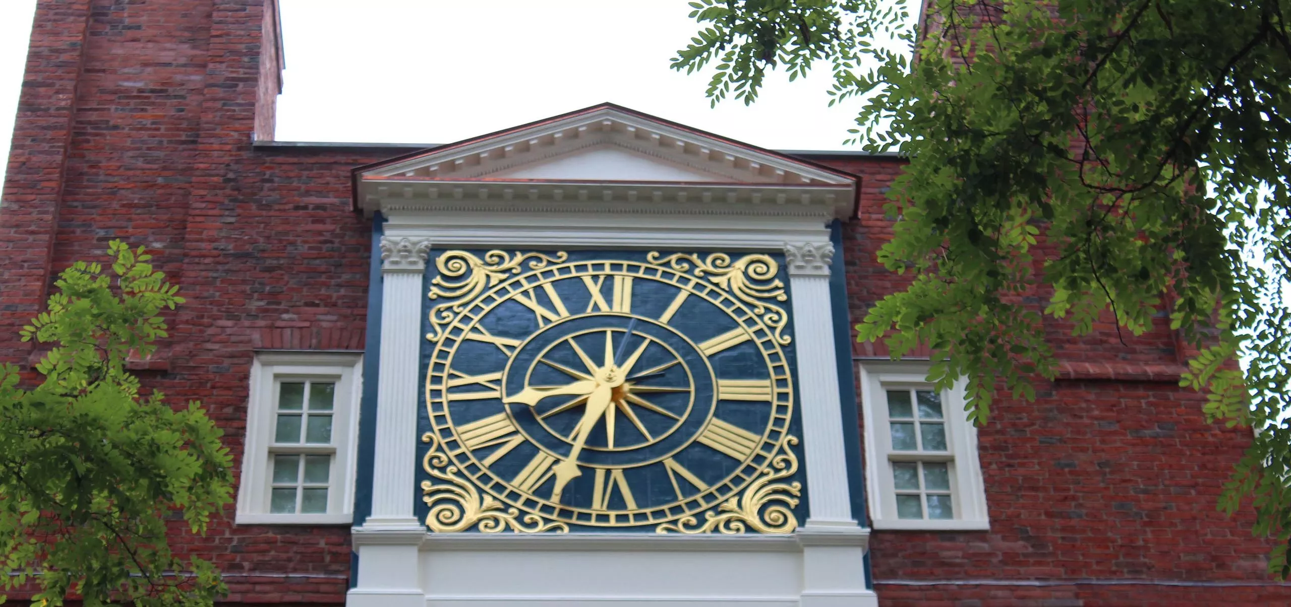 Large clock on the side of Massachusetts Hall