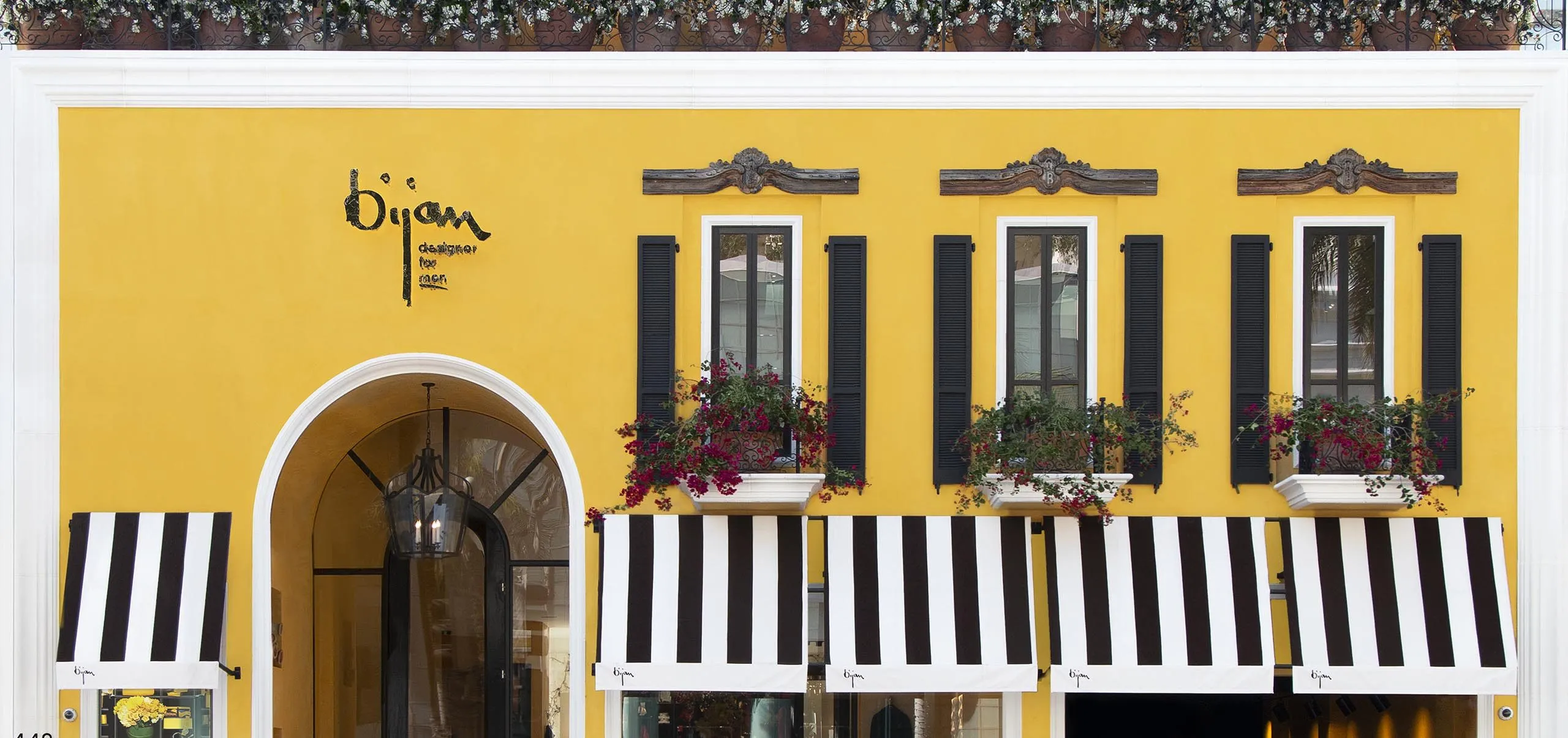 exterior view of house of bijan building with yellow sports car out front